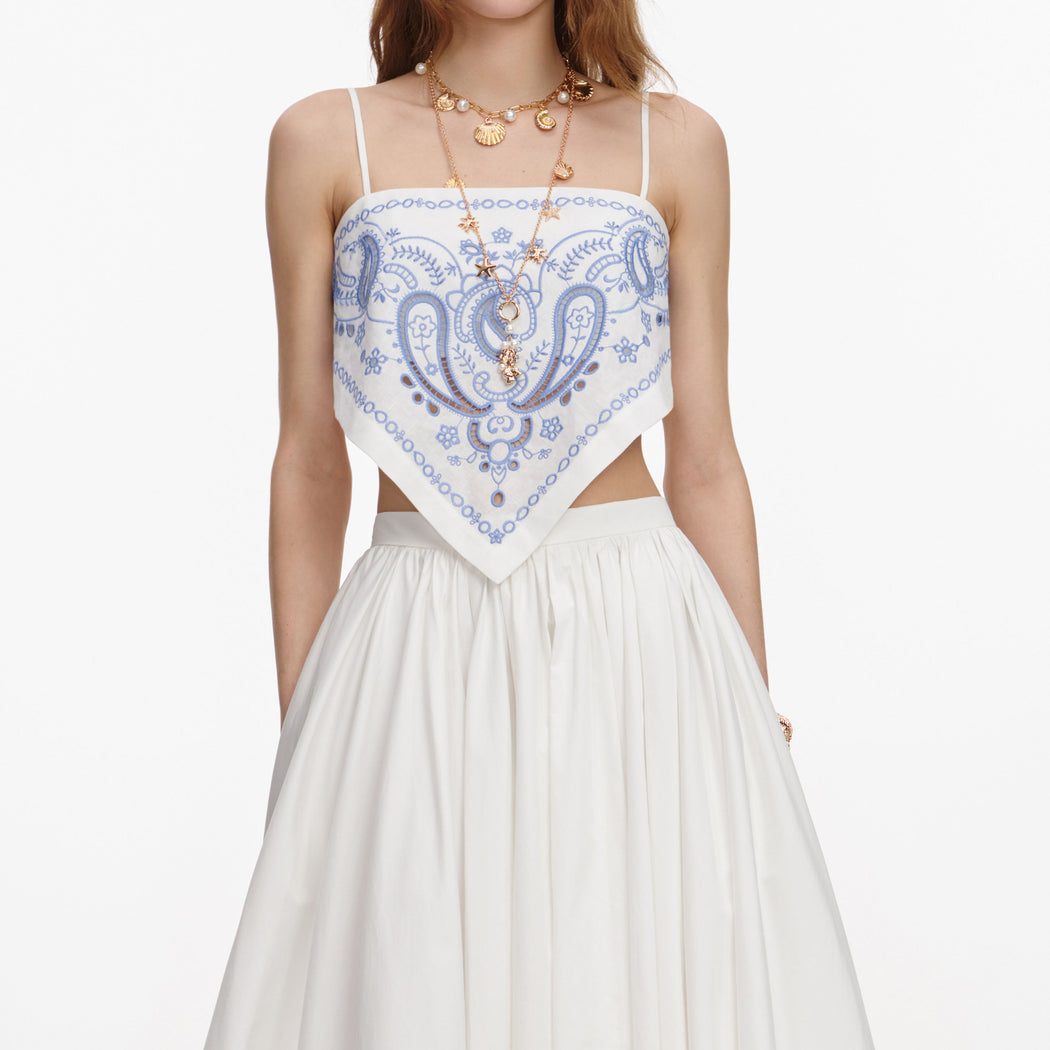 A close up of a woman wearing the White And Blue Embroidered Linen Top