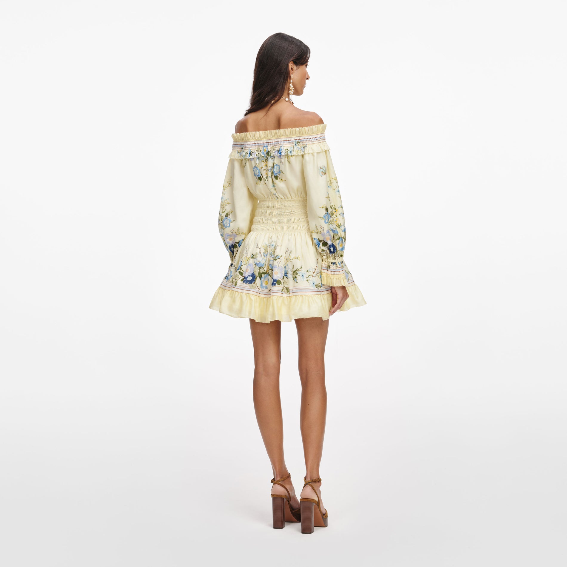 Back view of a woman wearing the Yellow Floral Organza Ruffle Mini Dress