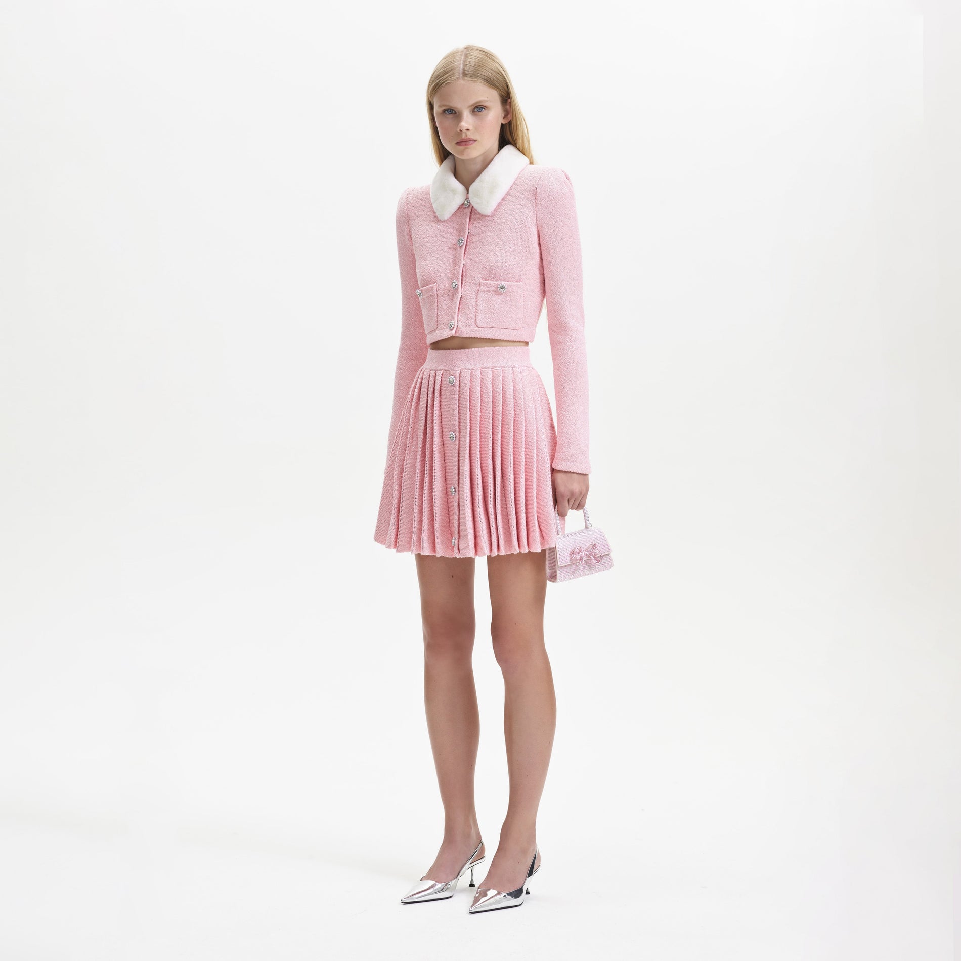 Side view of a woman wearing the Pink Pleated Knit Mini Skirt