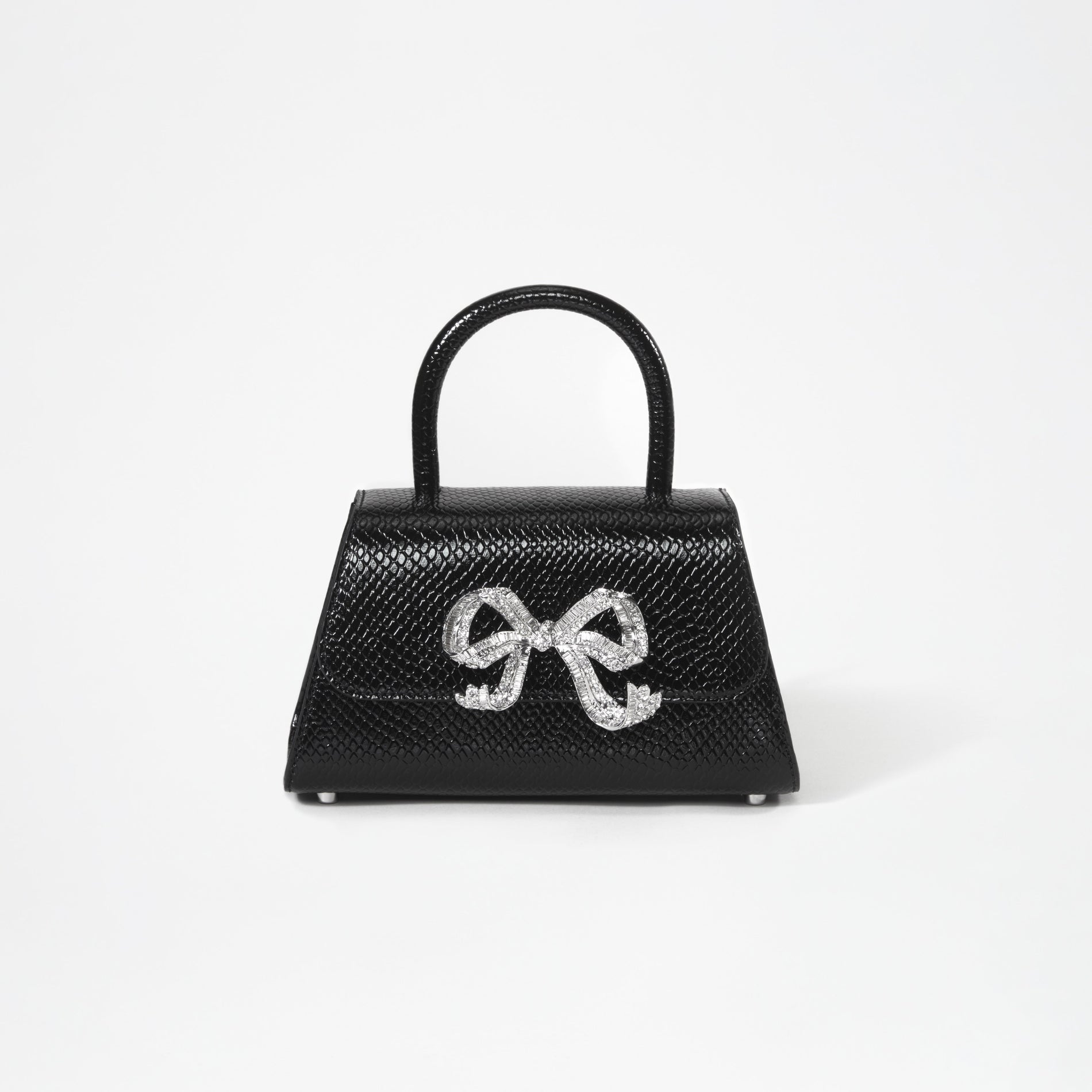 A woman wearing the Black Python Diamante Bow Mini Bag