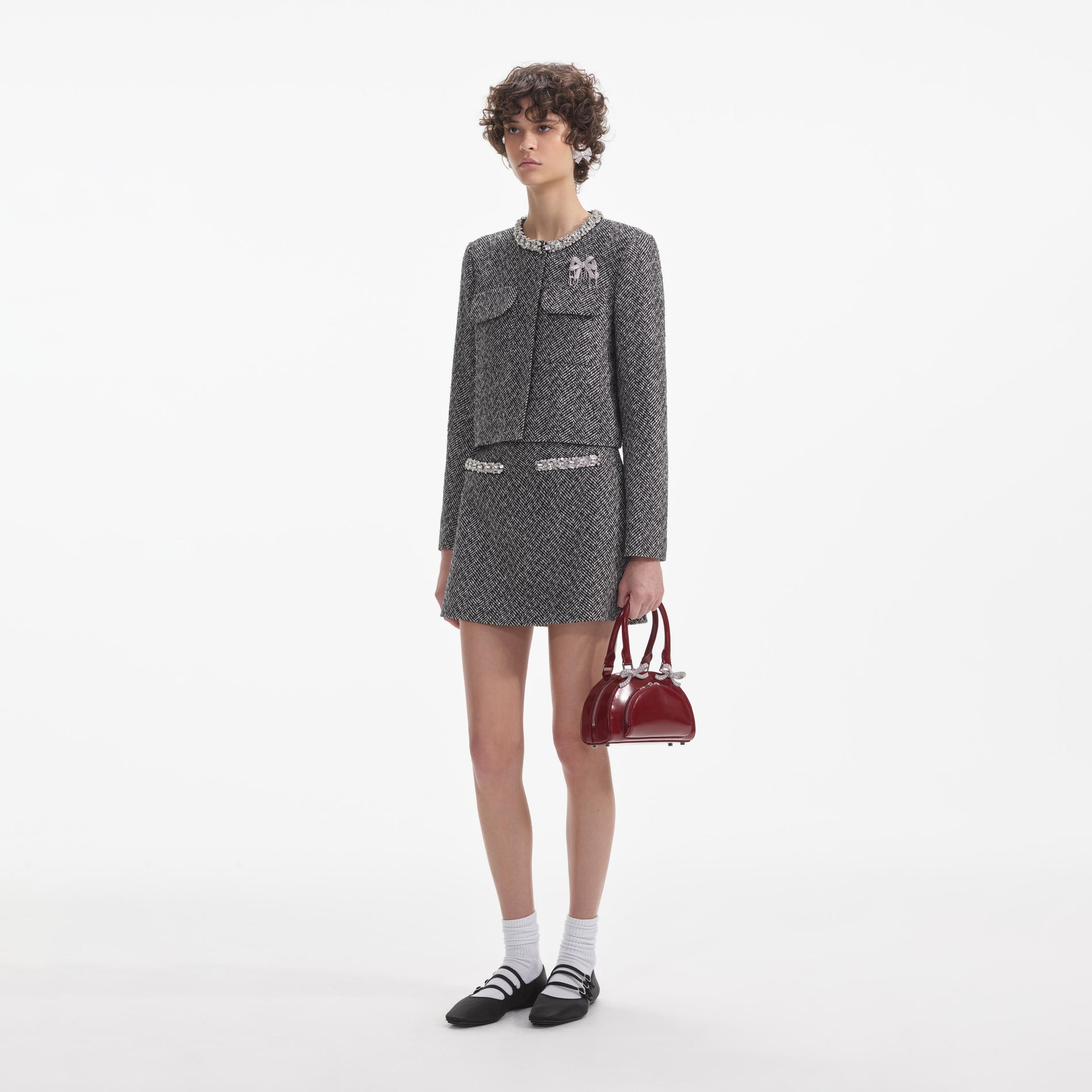 Side view of a woman wearing the Black Herringbone Embellished Jacket