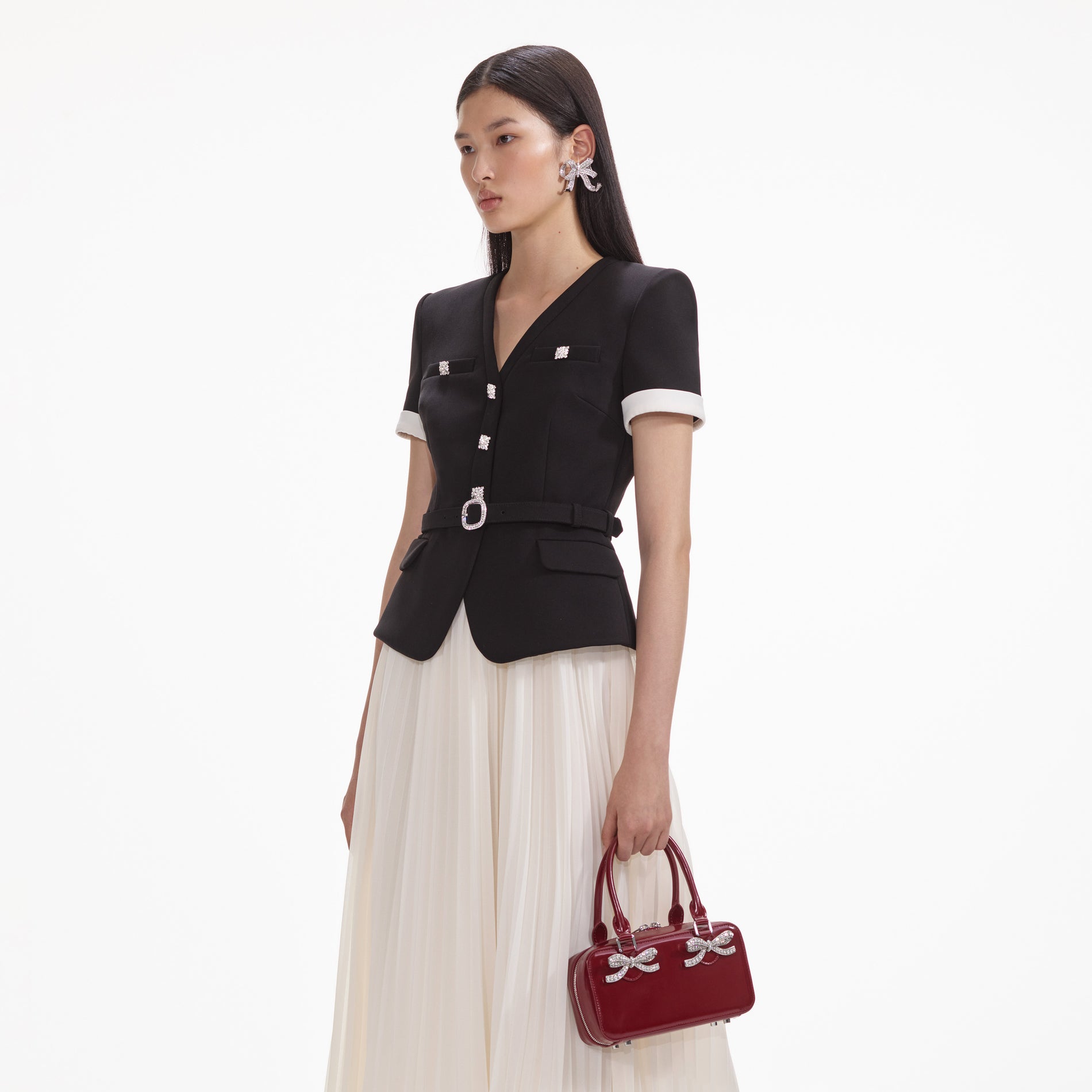 A close up of a woman wearing the Crystal Bow Earrings