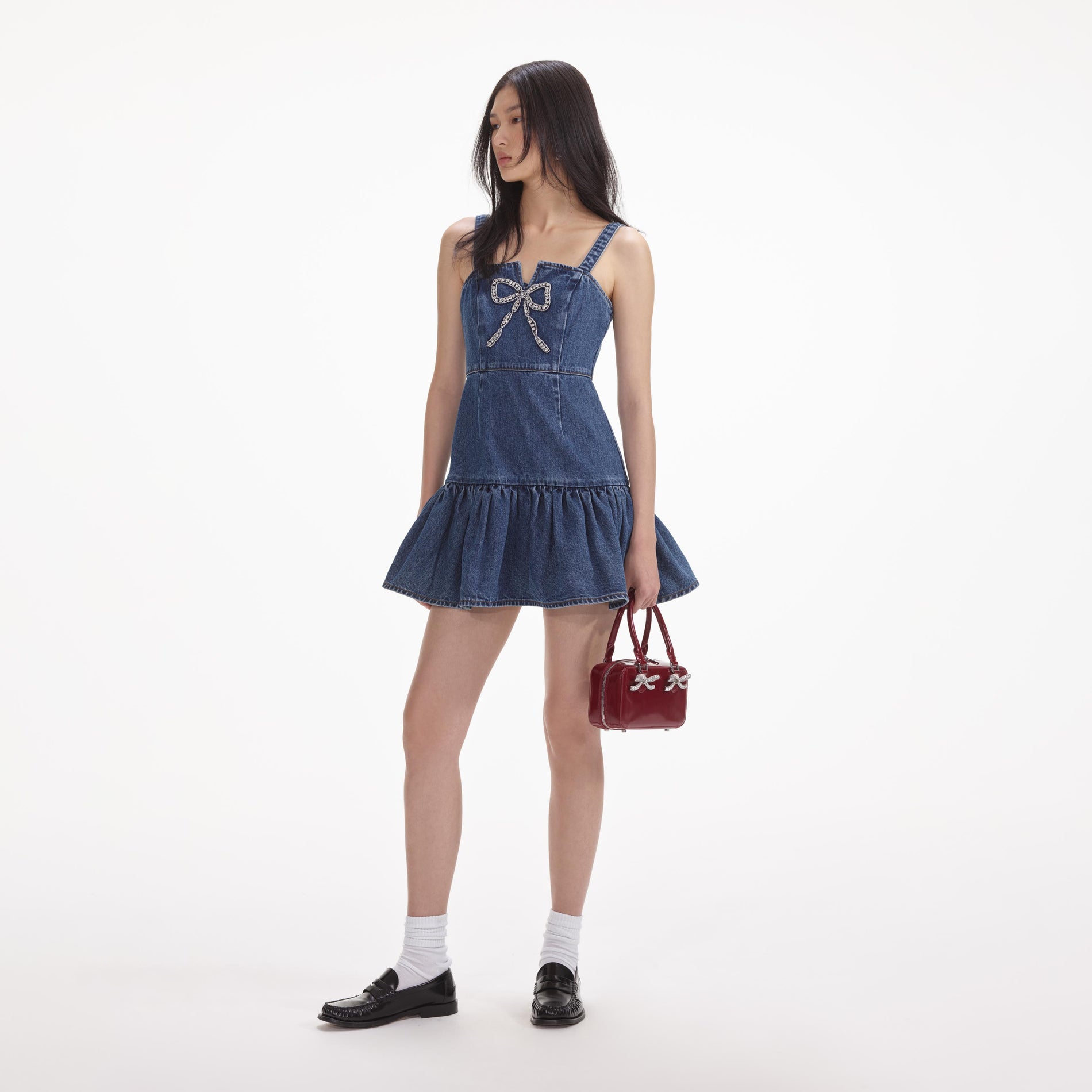 Side view of a woman wearing the Bow Denim Mini Dress