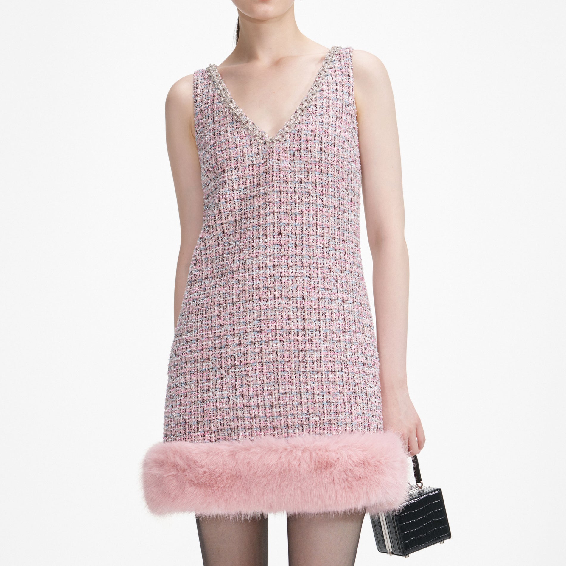 A close up of a woman wearing the Pink Boucle Fur Hem Mini Dress