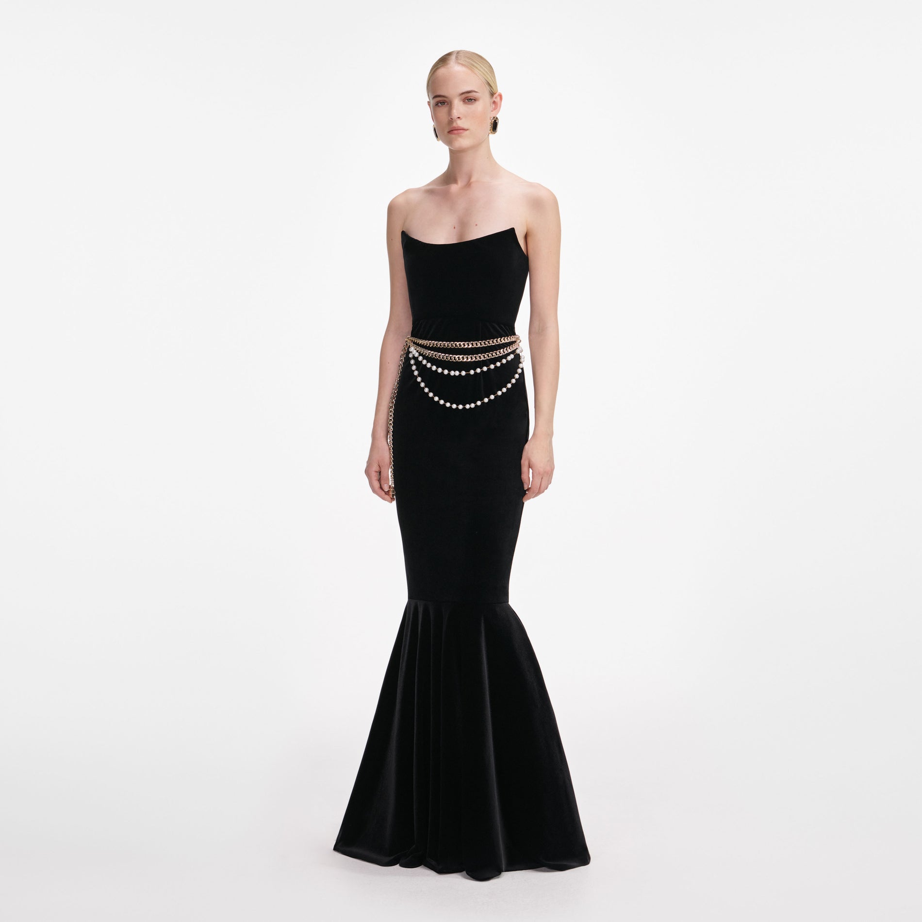 Side view of a woman wearing the Black Velvet Chain Belt Maxi Dress