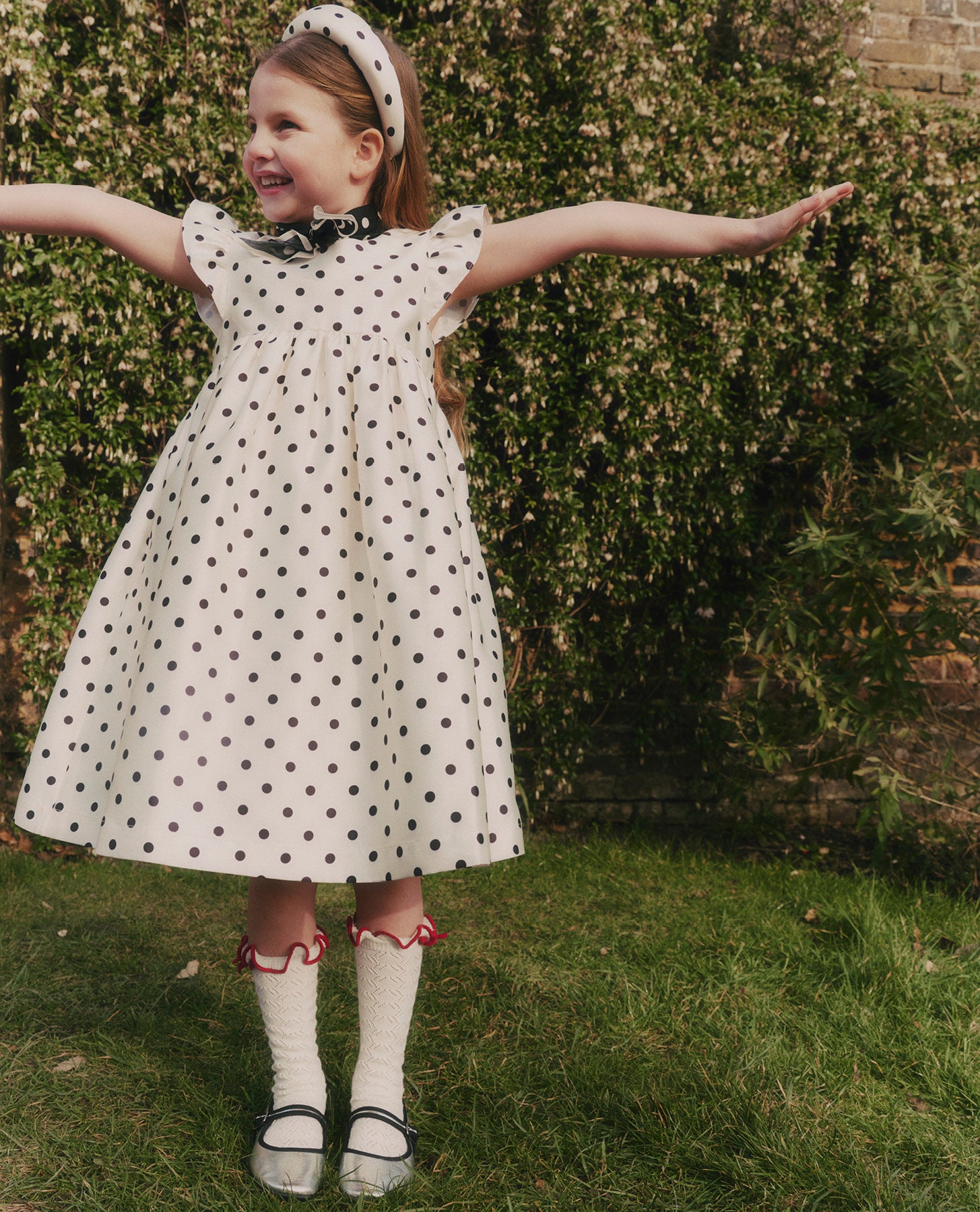 A close up of a woman wearing the Cream Polka Dot Taffeta Dress