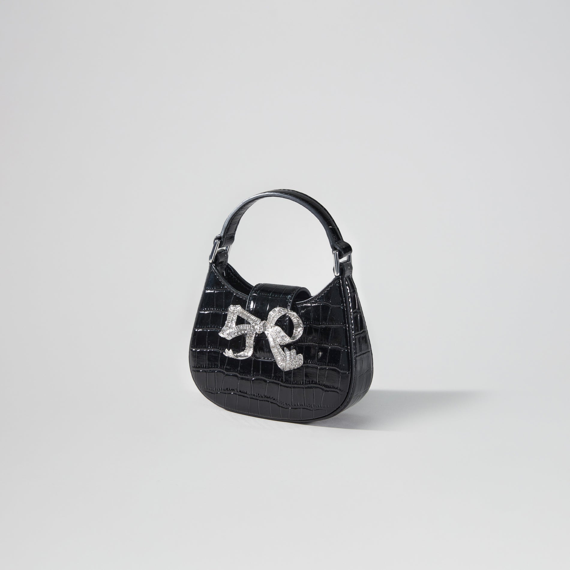 Side view of a woman wearing the Black Croc Crescent Bow Micro Bag