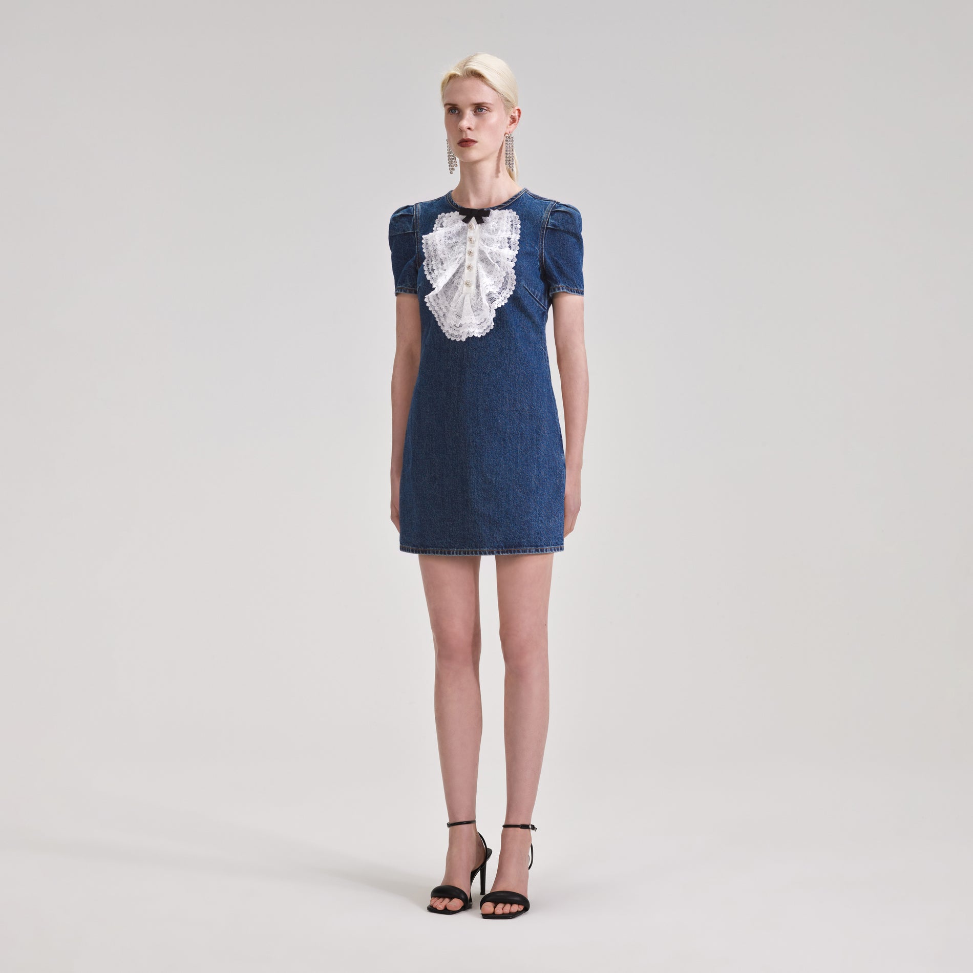 A woman wearing the Lace Bib Denim Mini Dress