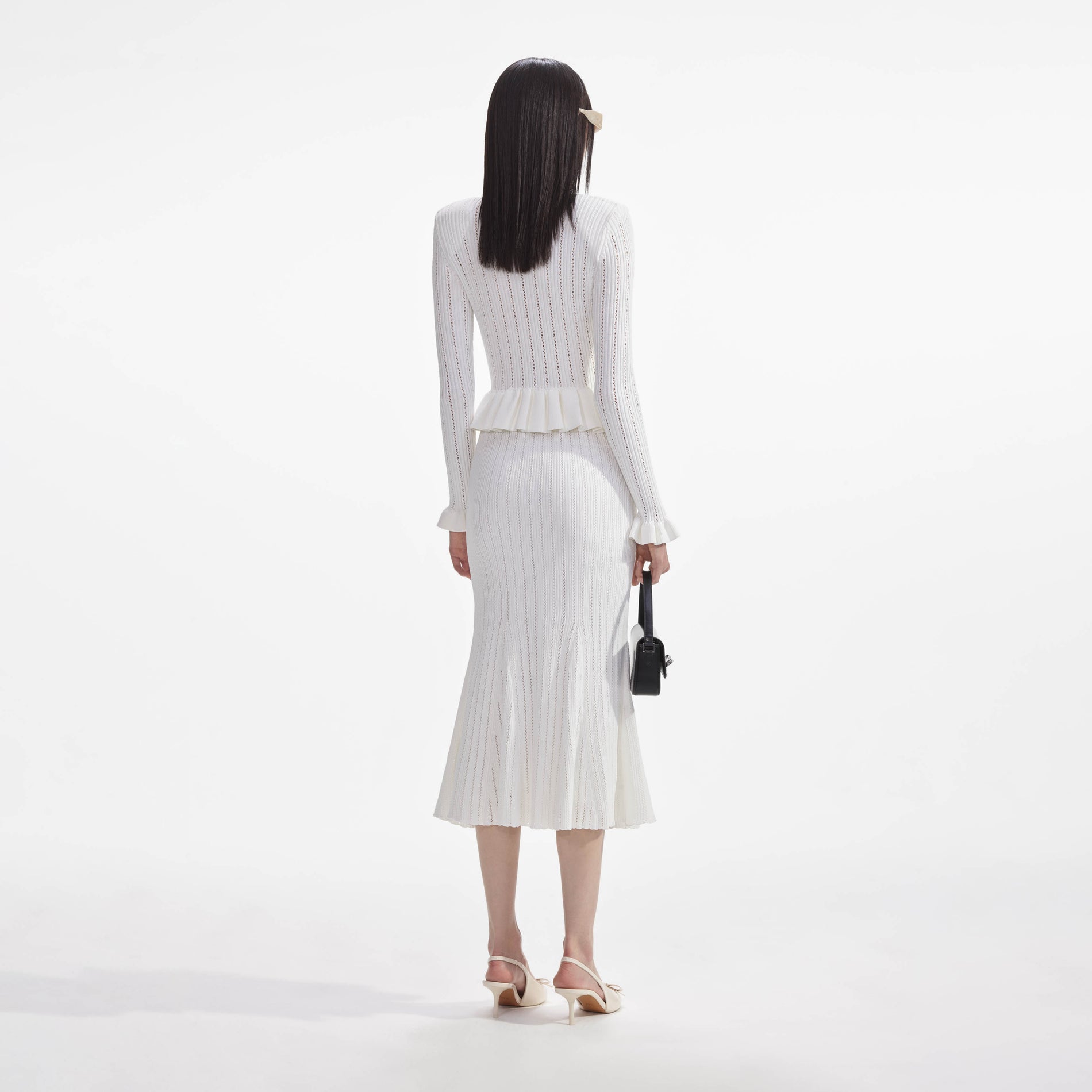 Back view of a woman wearing the White Knit Peplum Midi Dress