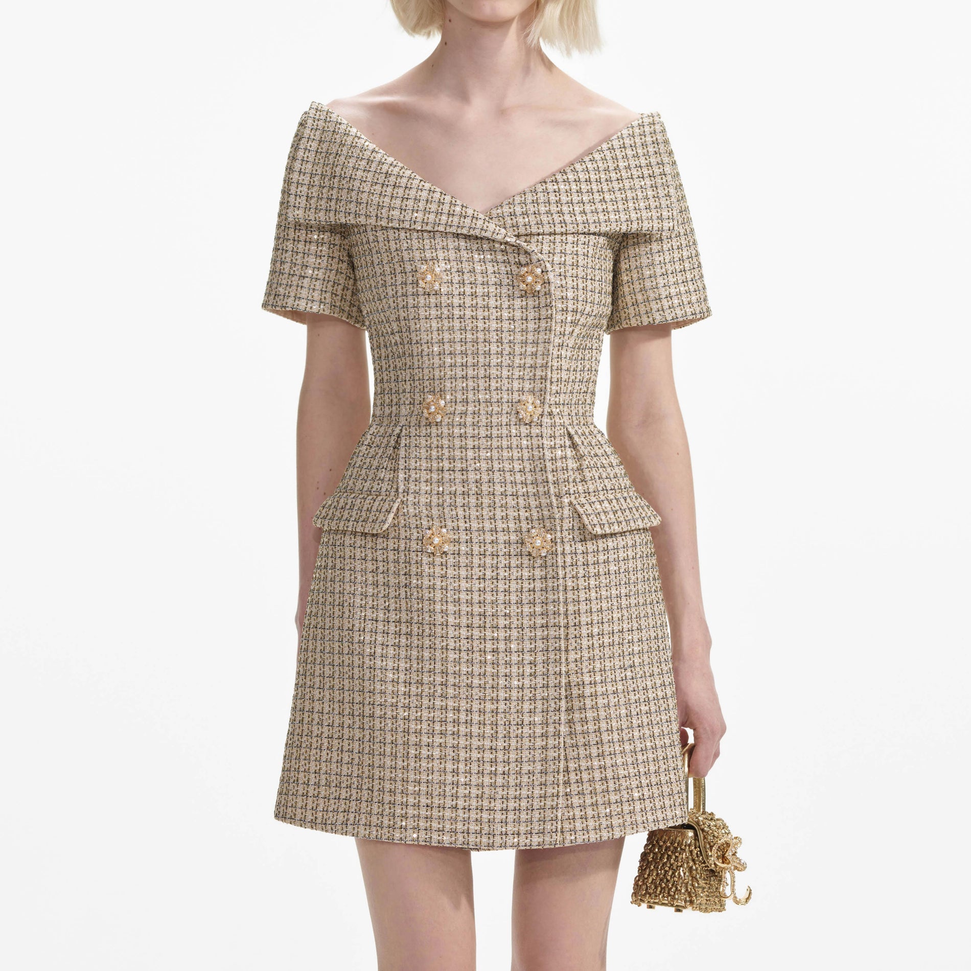 A close up of a woman wearing the Gold Boucle Open Neck Mini Dress