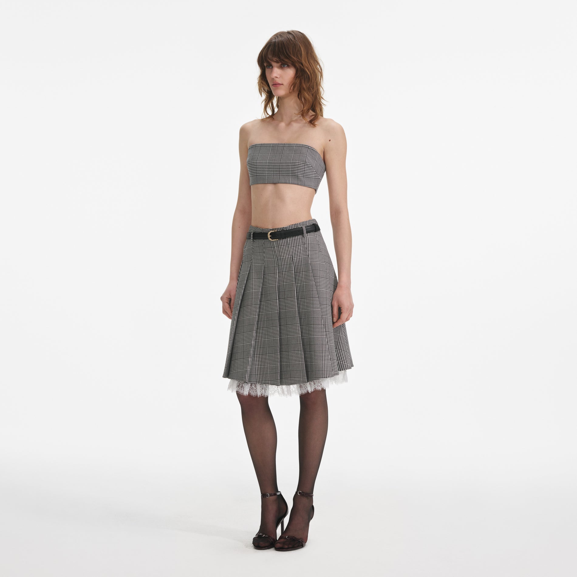 Side view of a woman wearing the Prince Of Wales Check Pleated Midi Skirt