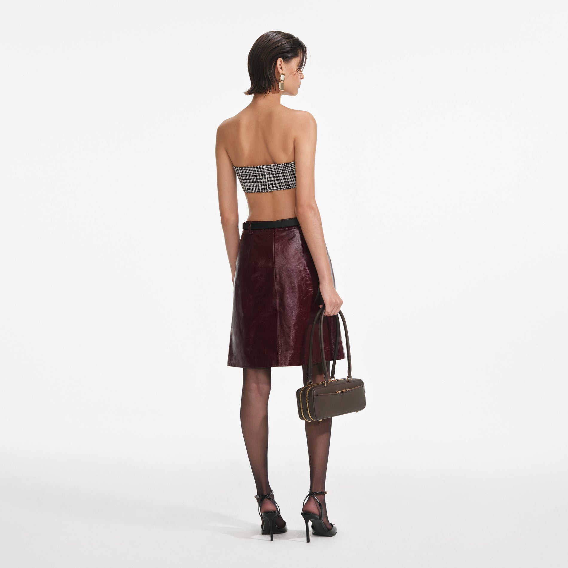 Back view of a woman wearing the Burgundy Leather Mini Skirt