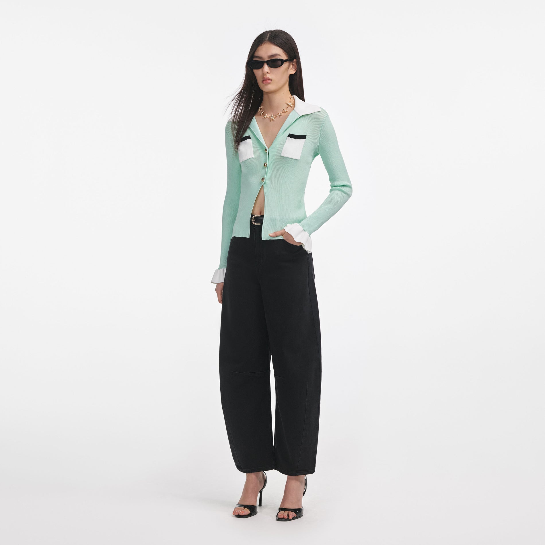 Side view of a woman wearing the Green Ribbed Viscose Knit Top