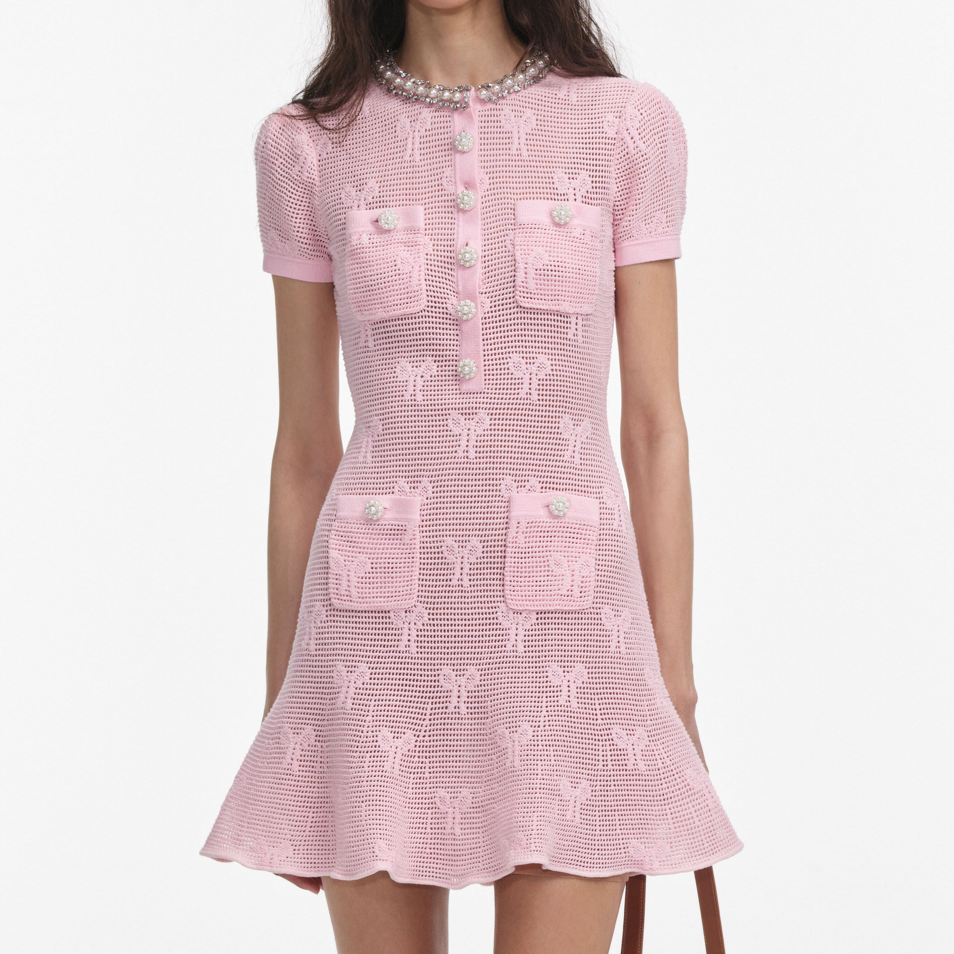 A close up of a woman wearing the Pink Bow Crochet Crystal Trim Mini Dress