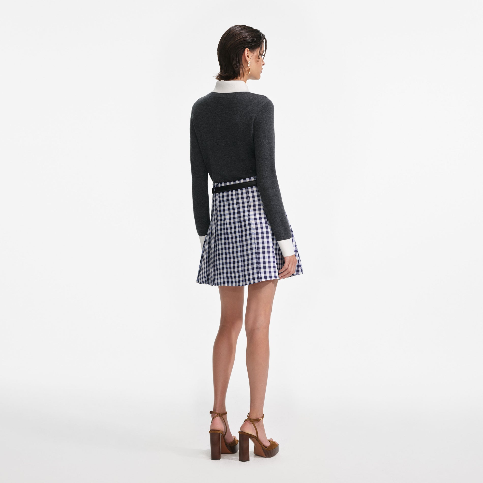Back view of a woman wearing the Navy Gingham Pleated Taffeta Mini Skirt