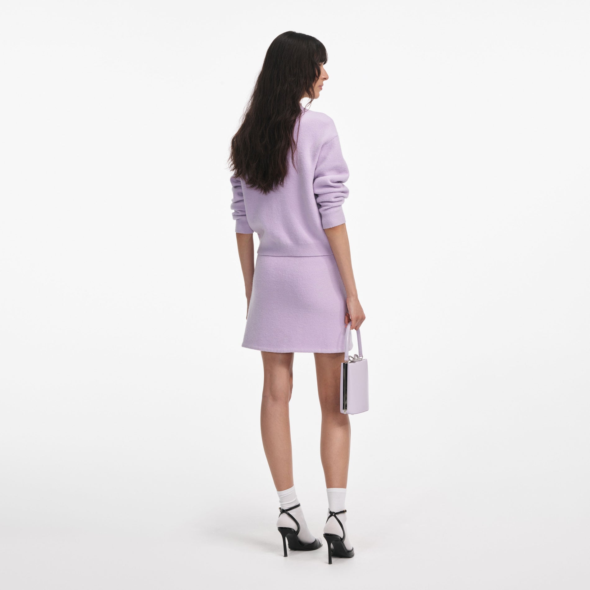 Back view of a woman wearing the Lilac Crystal Trim Knit Skirt