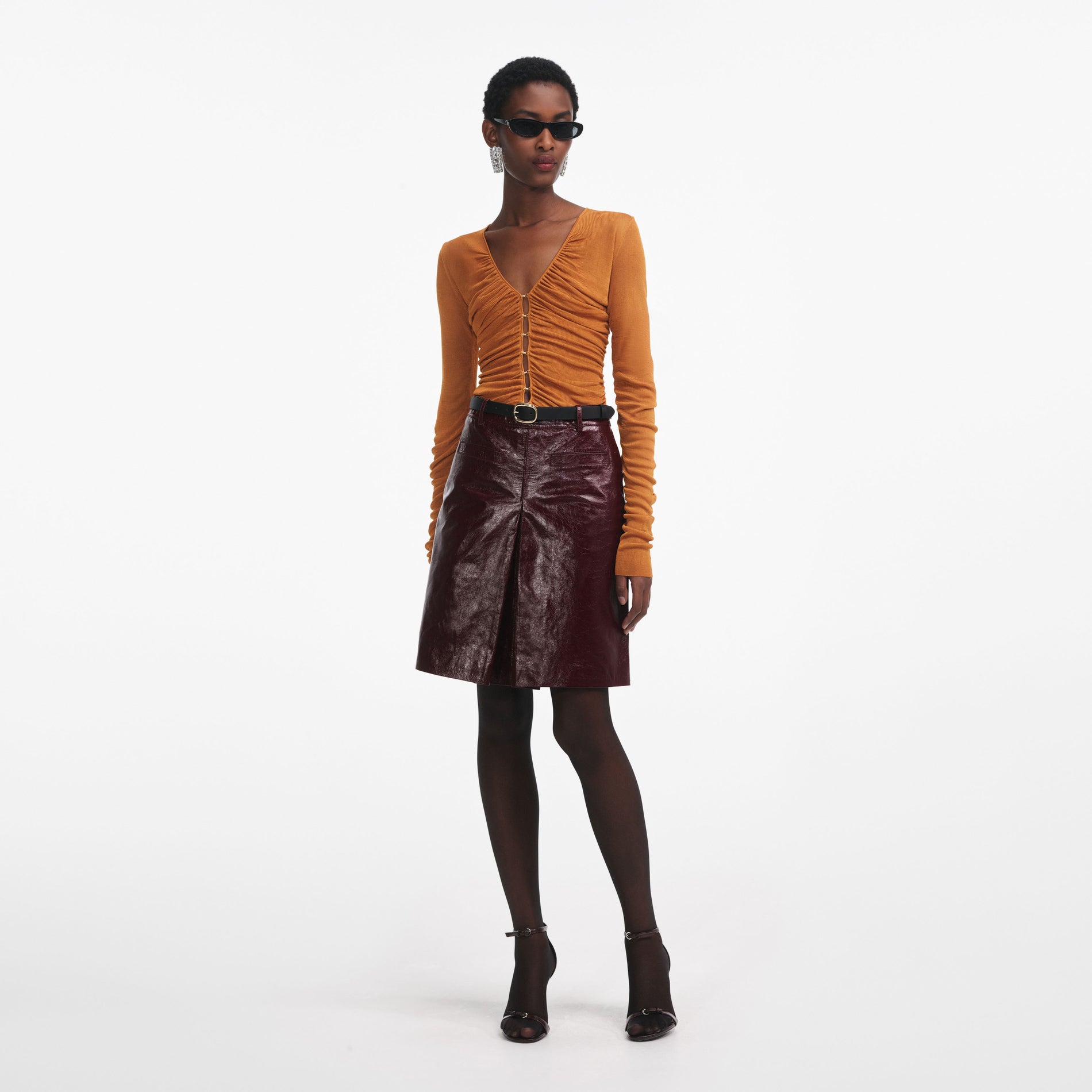 Side view of a woman wearing the Burnt Orange V Neck Viscose Knit Top