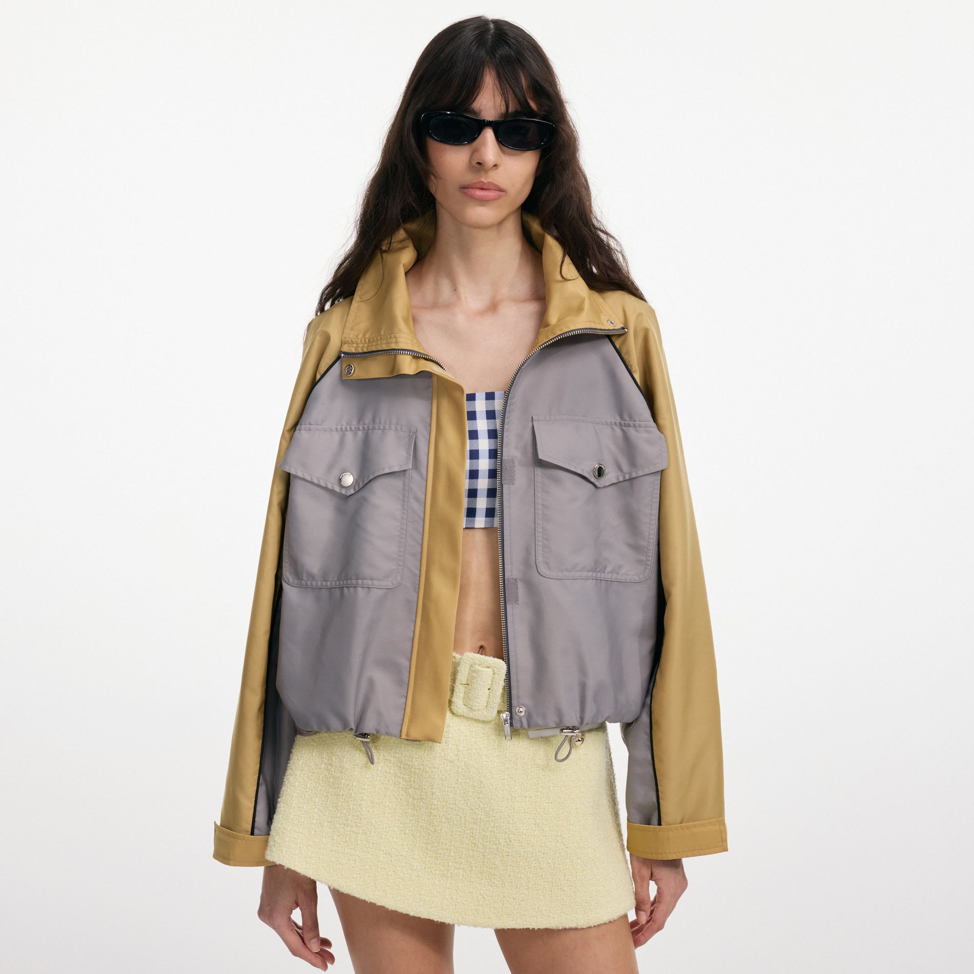A close up of a woman wearing the Grey Nylon Cropped Windbreaker