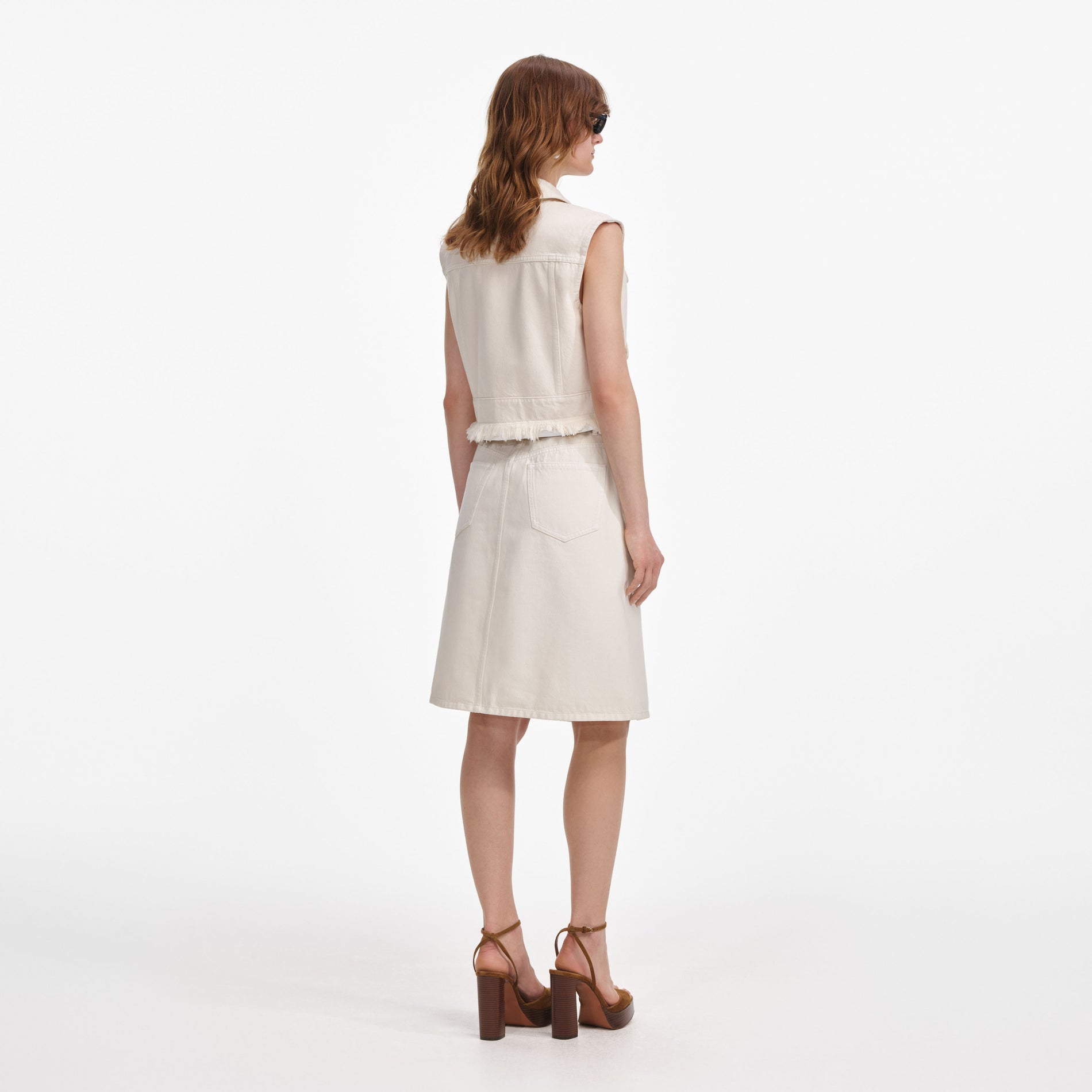 Back view of a woman wearing the Cream Denim Midi Skirt