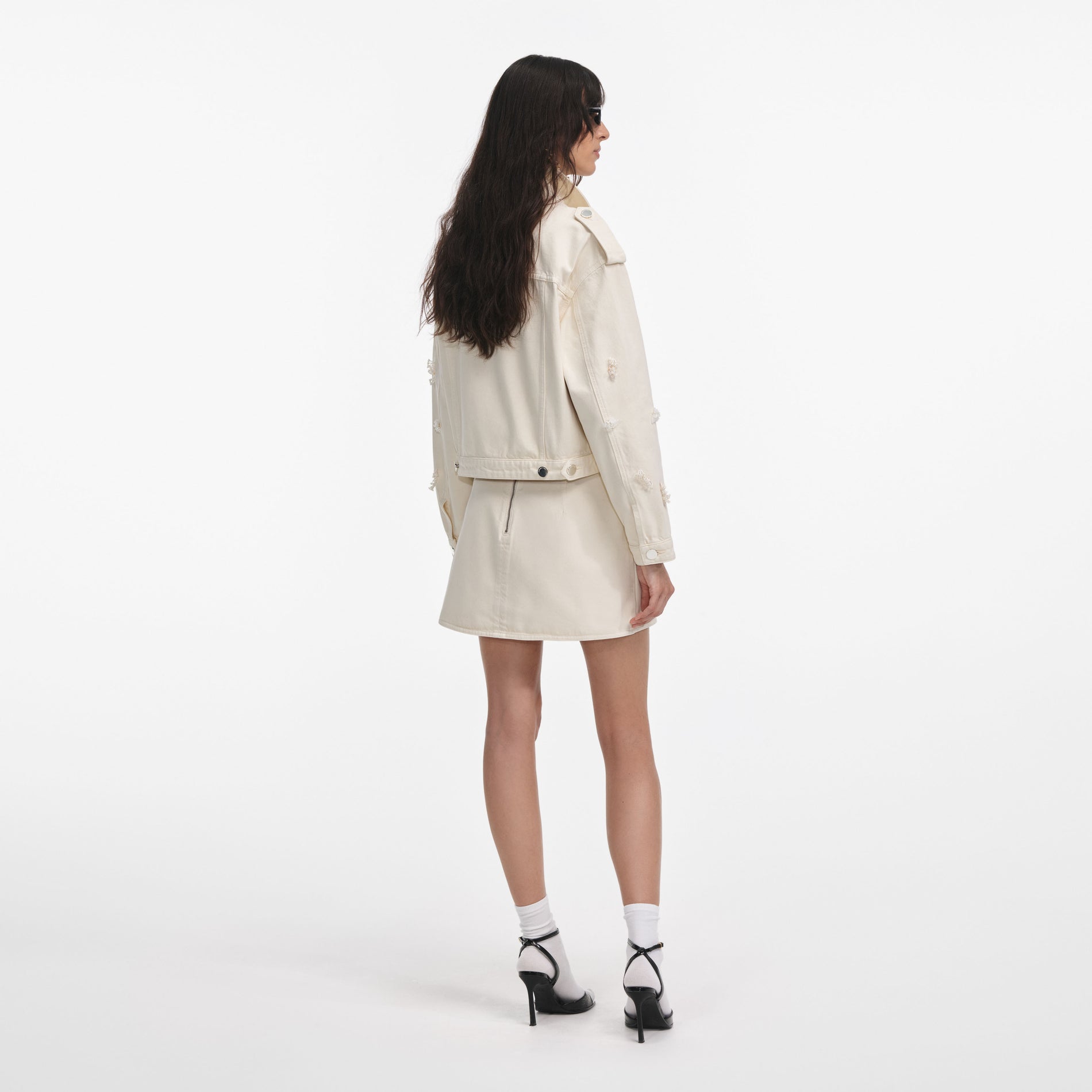 Back view of a woman wearing the Cream Denim Beaded Floral Jacket