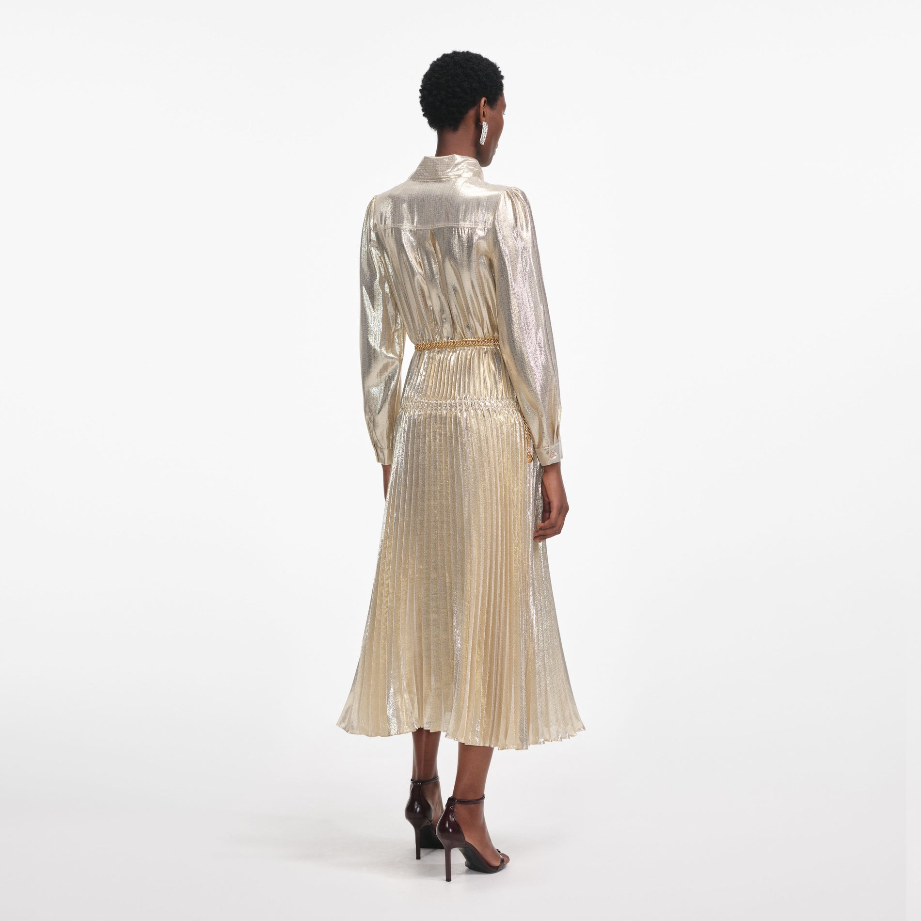 Back view of a woman wearing the Gold Metallic Pussy Bow Midi Dress