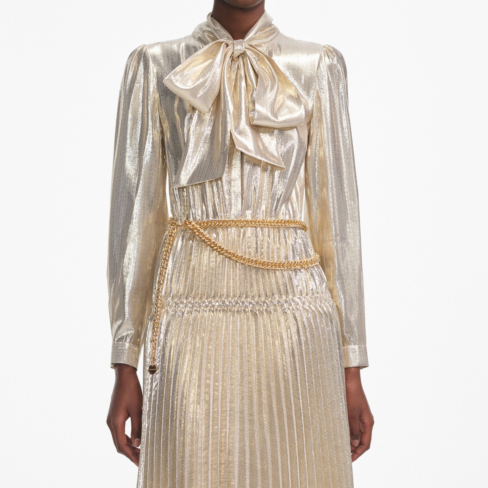 A close up of a woman wearing the Gold Metallic Pussy Bow Midi Dress