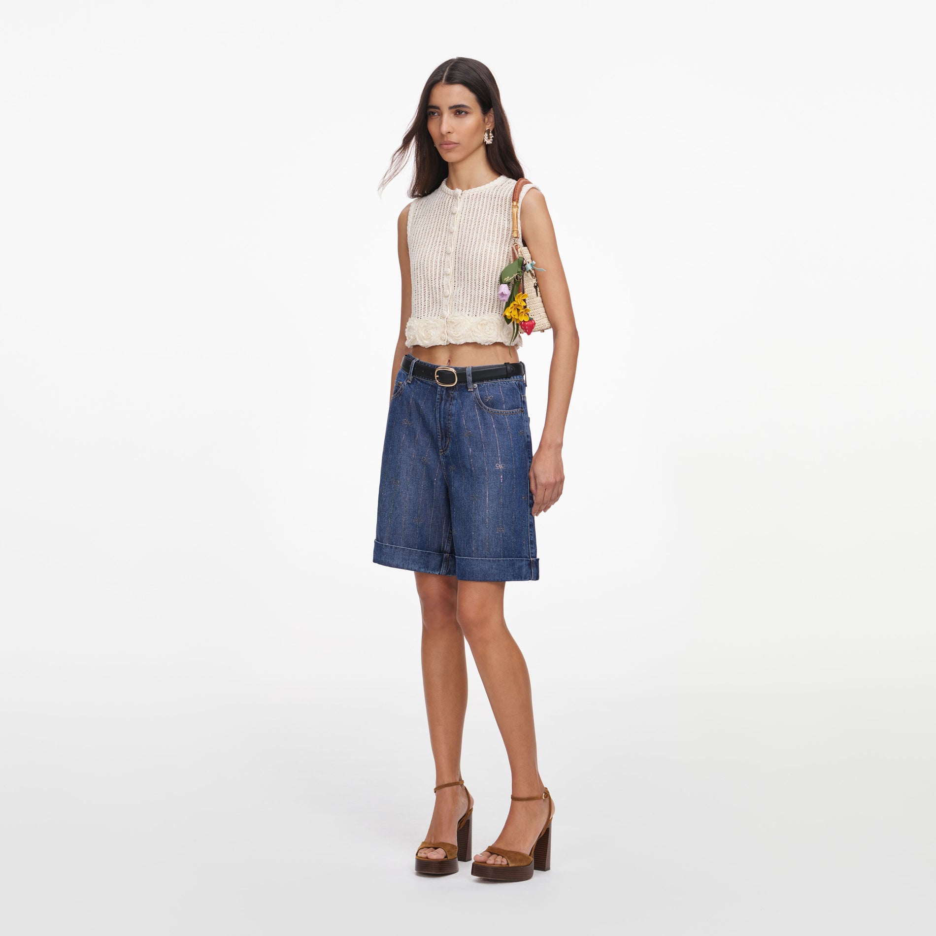 Side view of a woman wearing the Cream Crochet Flower Knit Top