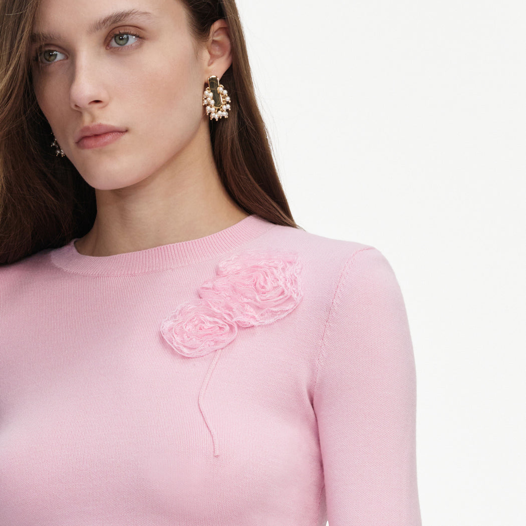 A close up of a woman wearing the Pink Flower Knit Jumper