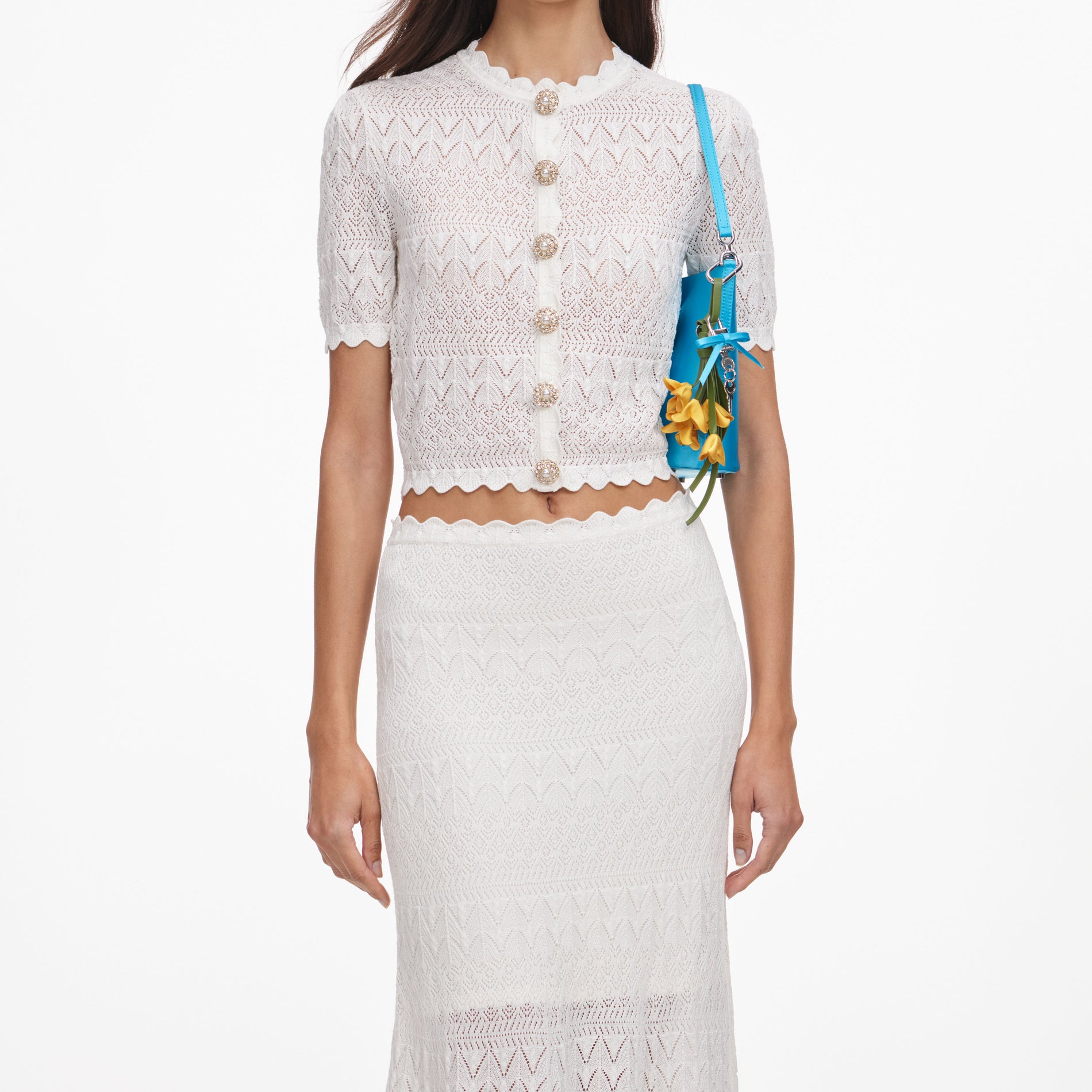 A close up of a woman wearing the White Pointelle Knit Midi Skirt