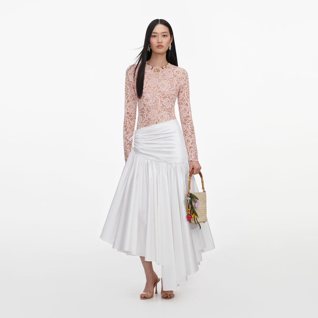 Front view of a woman wearing the White Cotton Asymmetric Midi Skirt