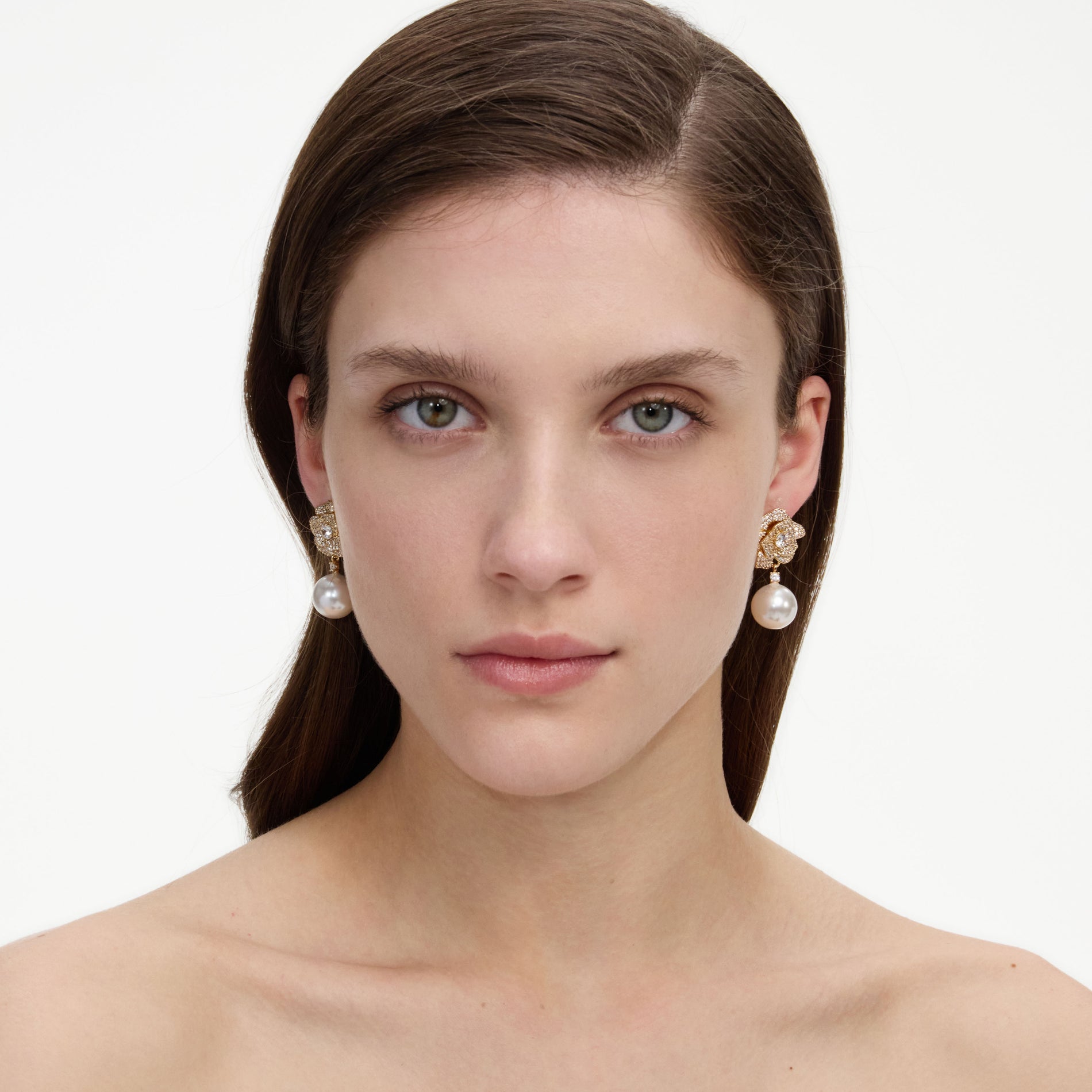 A close up of a woman wearing the Mini Gold Crystal Flower Pearl Earrings