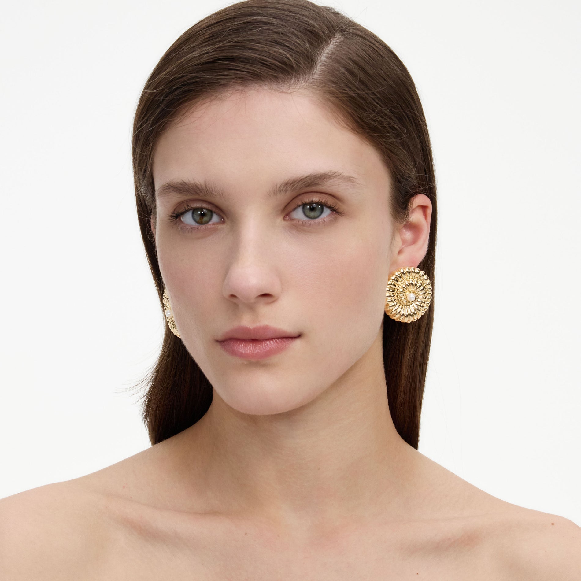 A close up of a woman wearing the Gold Pearl Shell Earrings