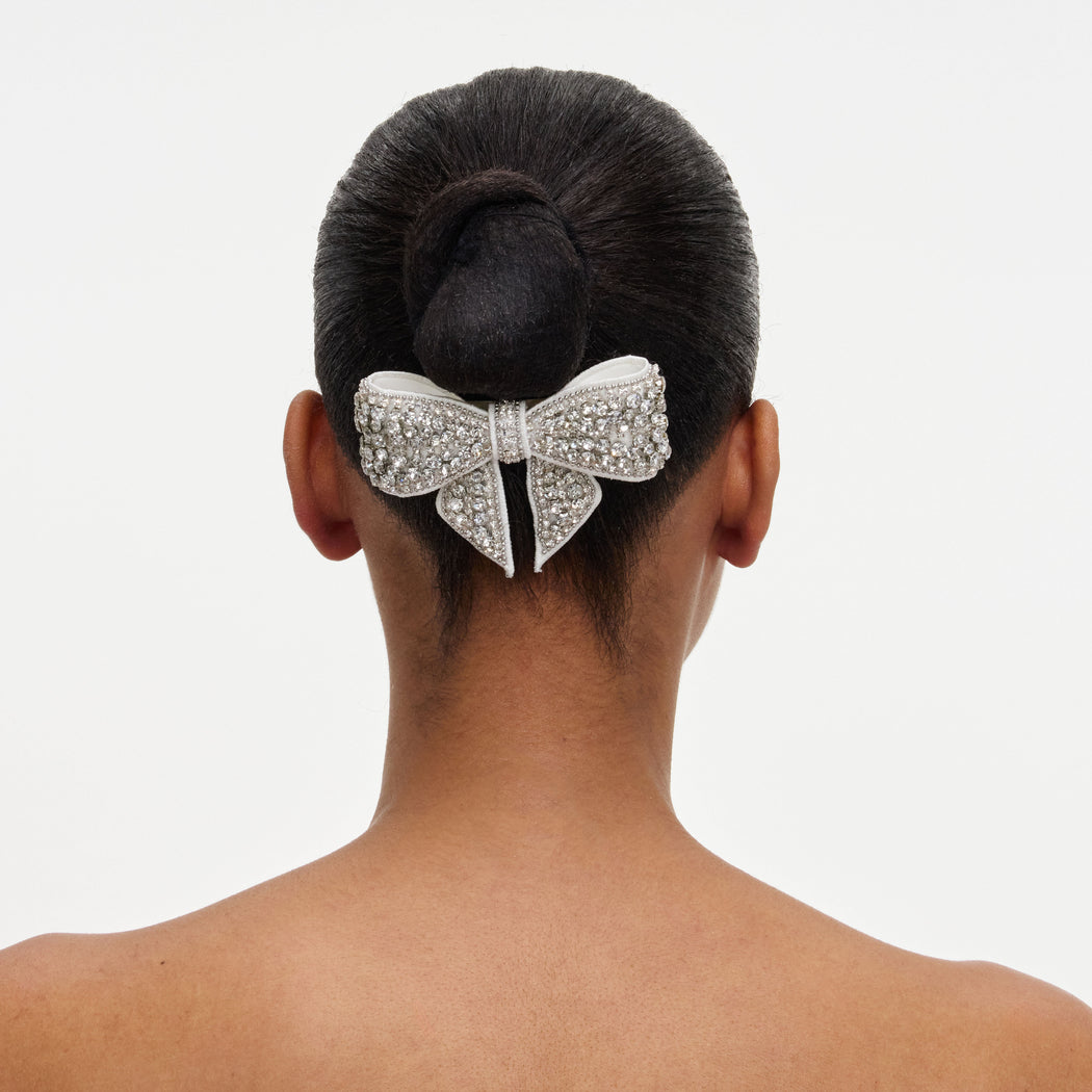 A close up of a woman wearing the Crystal Embellished Bow Hairclip