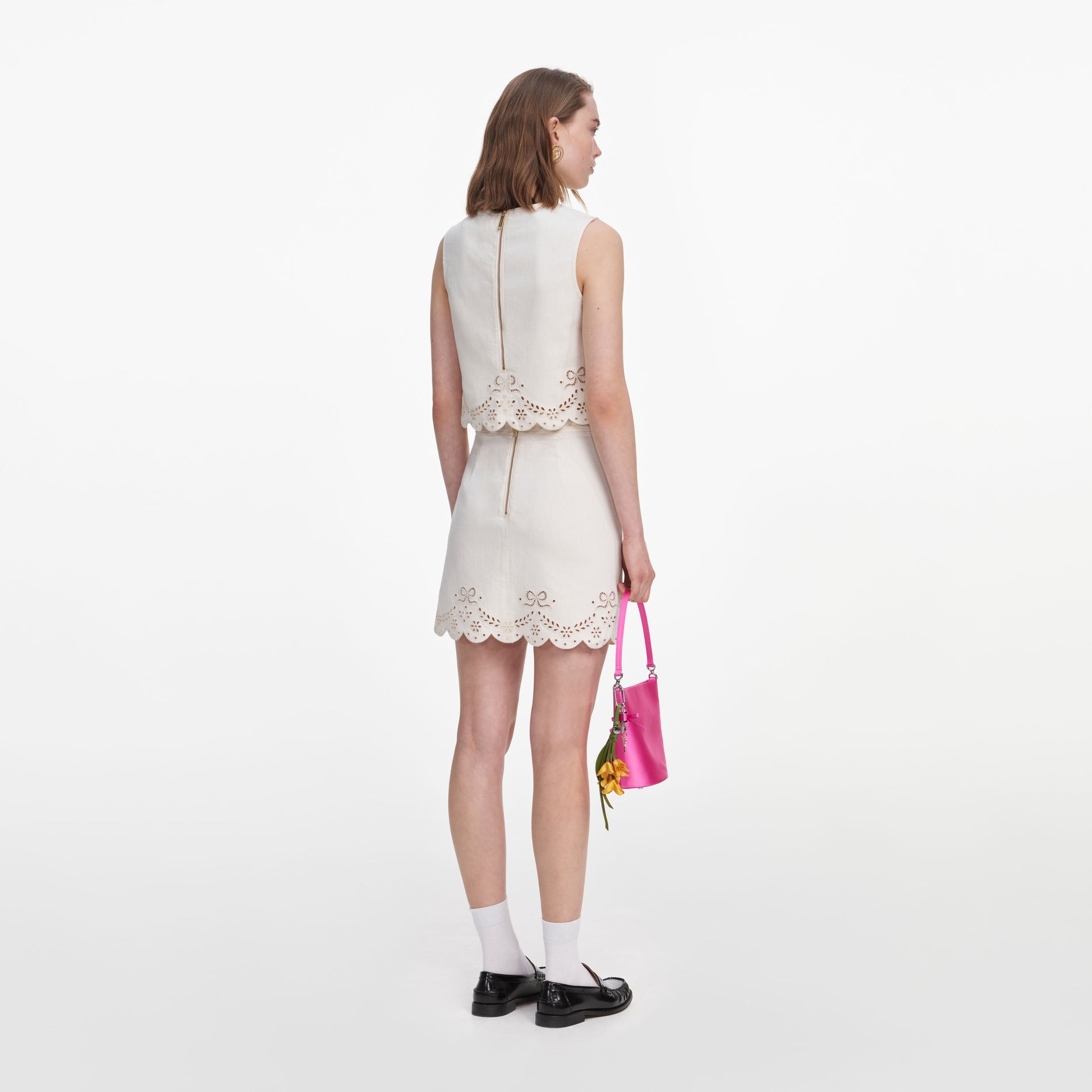 Back view of a woman wearing the Cream Broderie Denim Mini Skirt