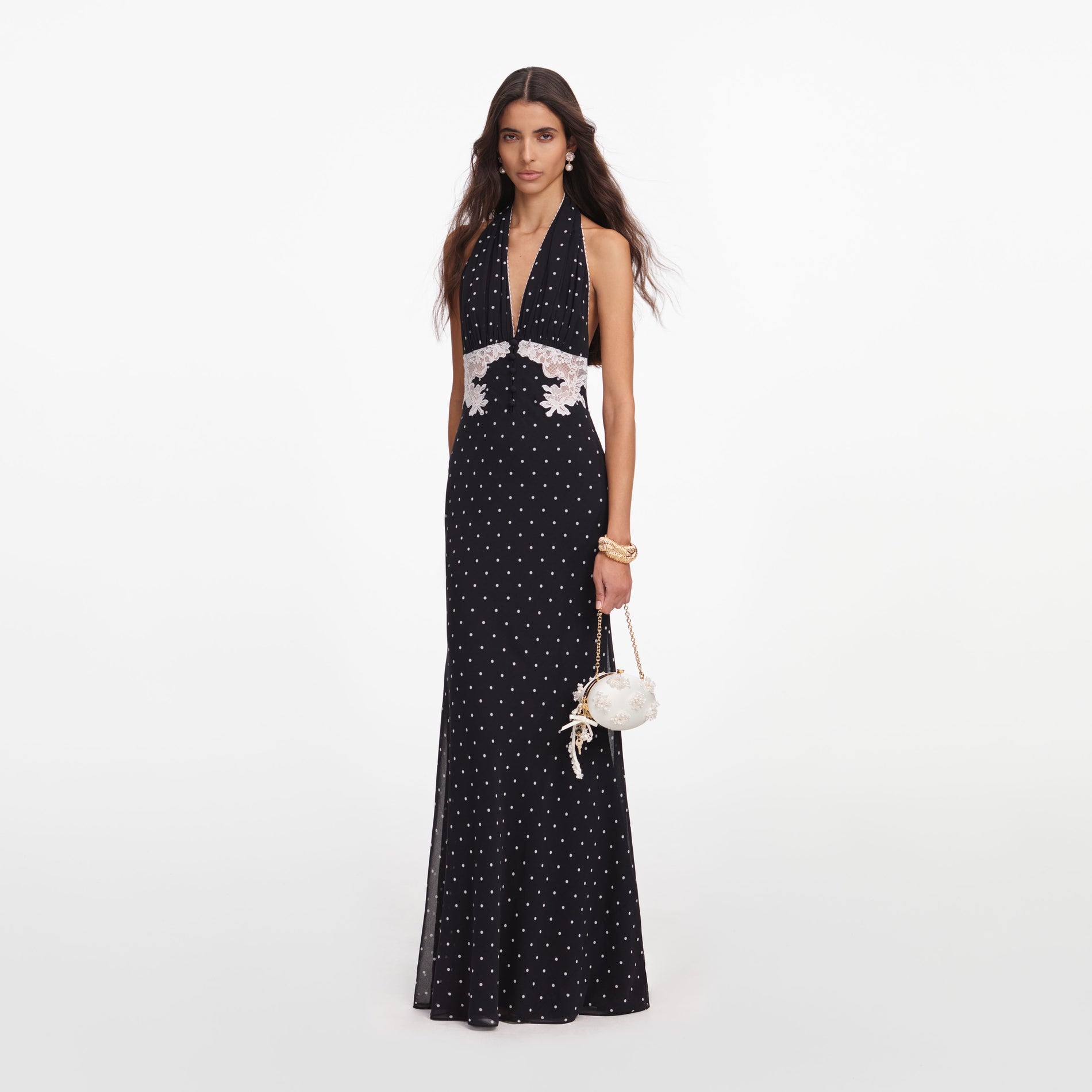 Side view of a woman wearing the Black Polka Dot Halter Neck Maxi Dress