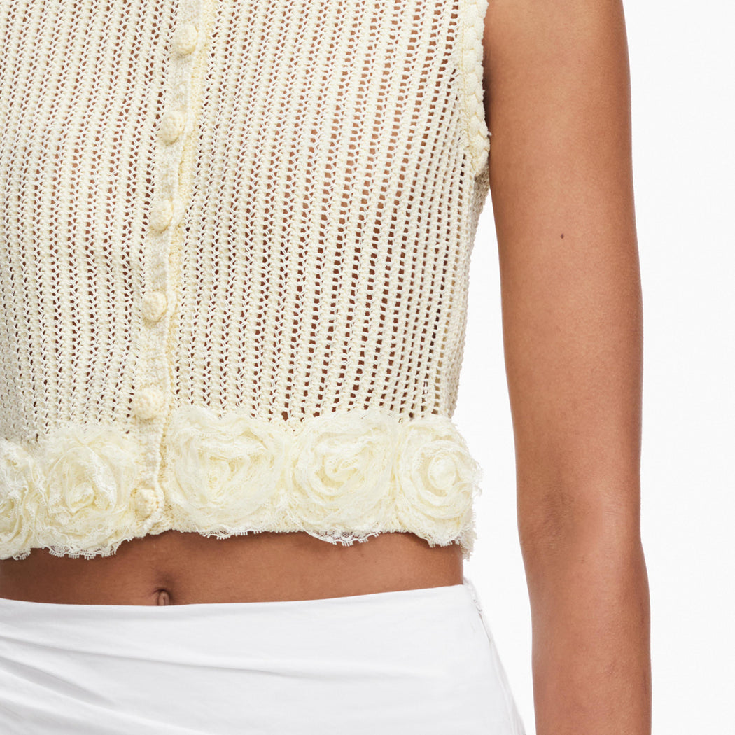 A close up of a woman wearing the Yellow Crochet Flower Knit Top
