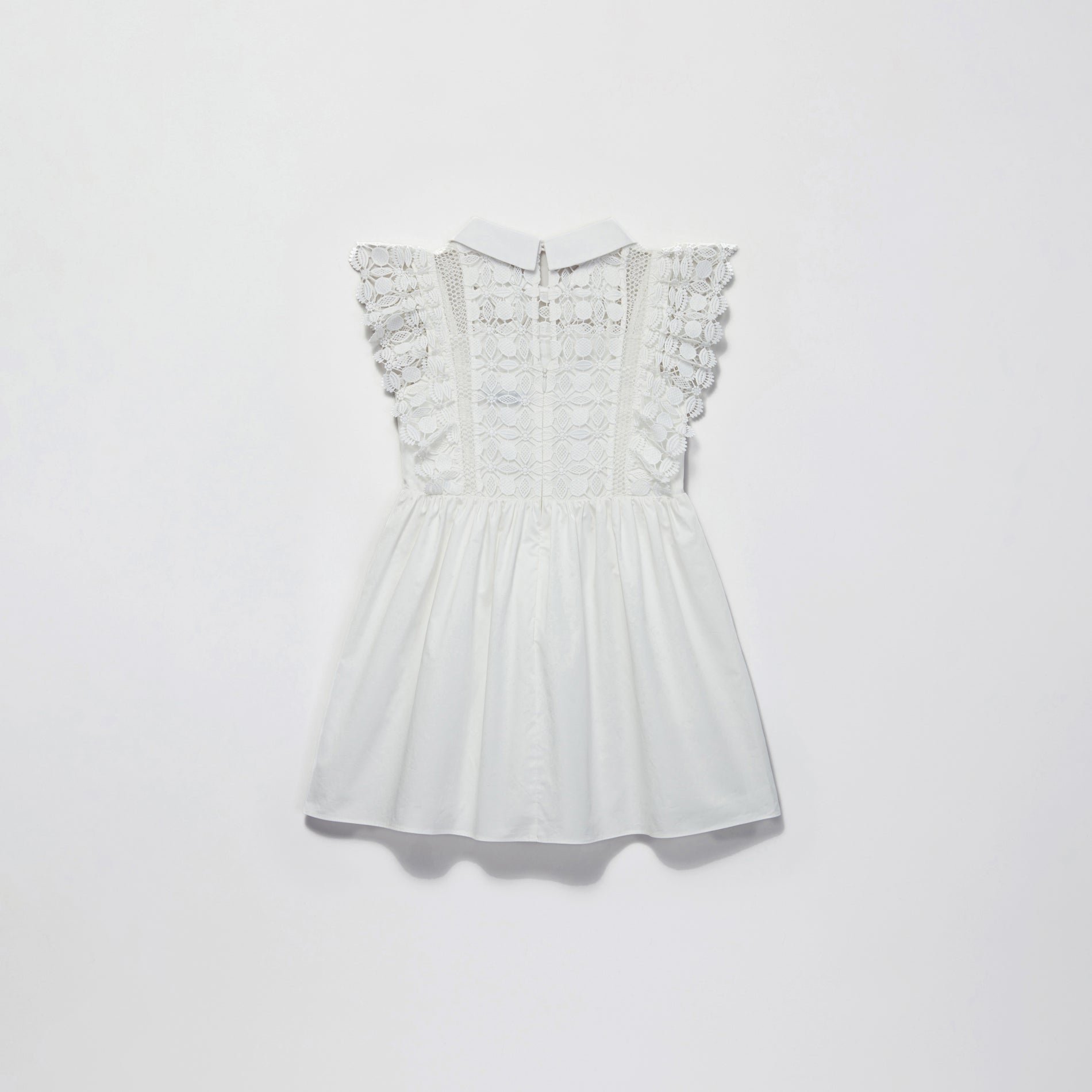 Side view of a woman wearing the White Lace Mini Dress