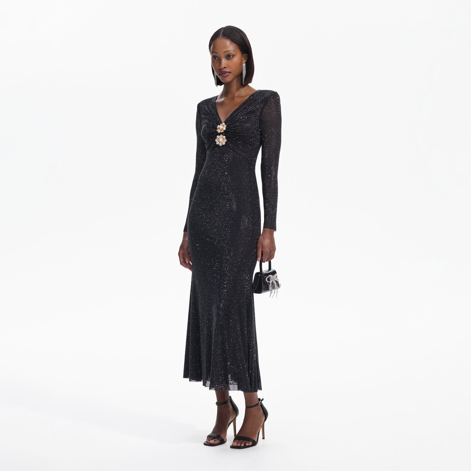 Side view of a woman wearing the Black Rhinestone Mesh V-Neck Midi Dress