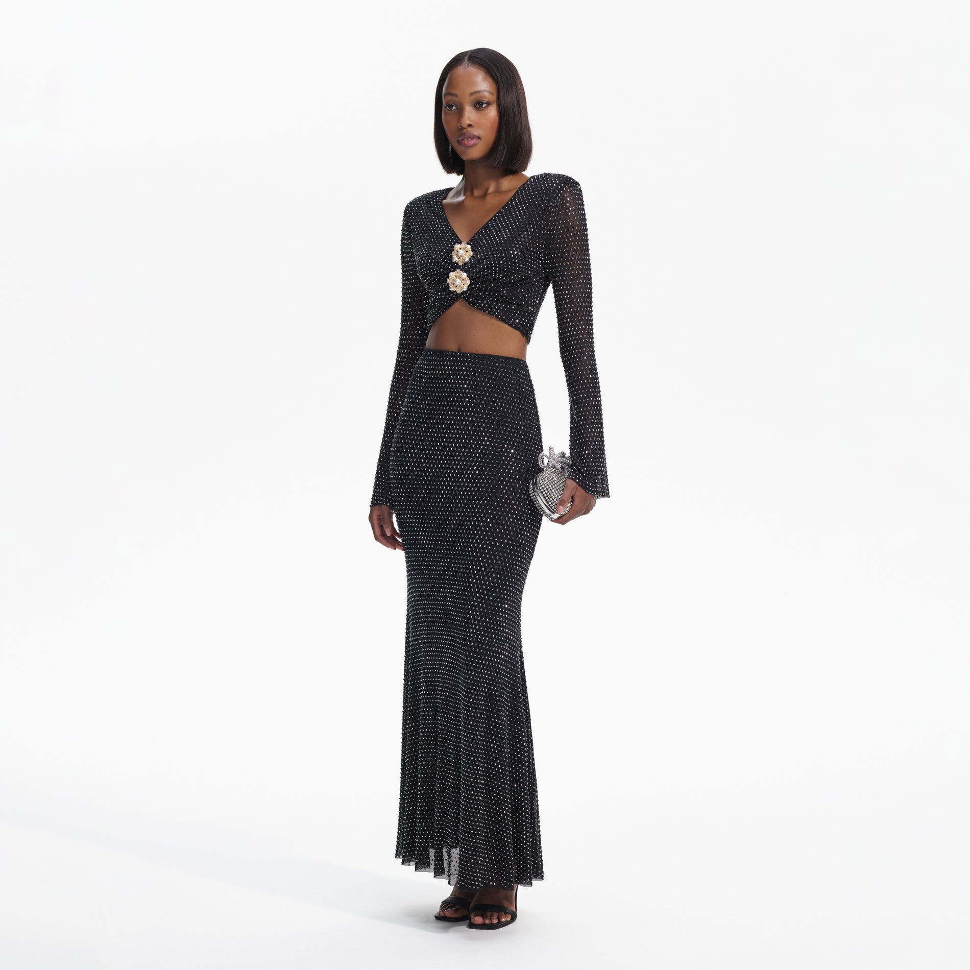 Side view of a woman wearing the Black Rhinestone Flared Sleeve Top