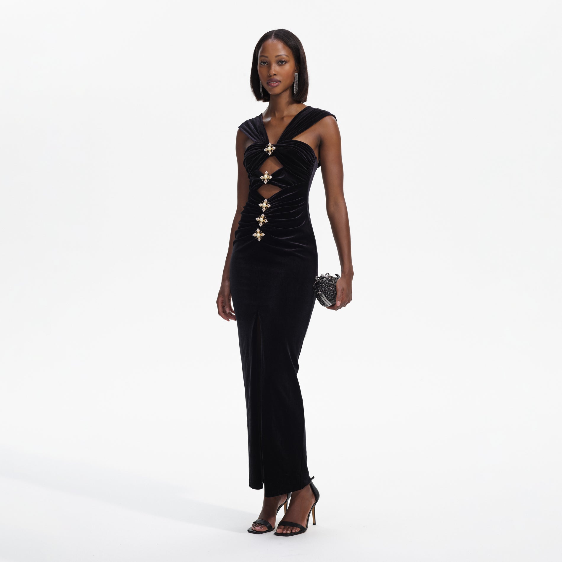 Side view of a woman wearing the Black Velvet Cut-Out Slit Maxi Dress