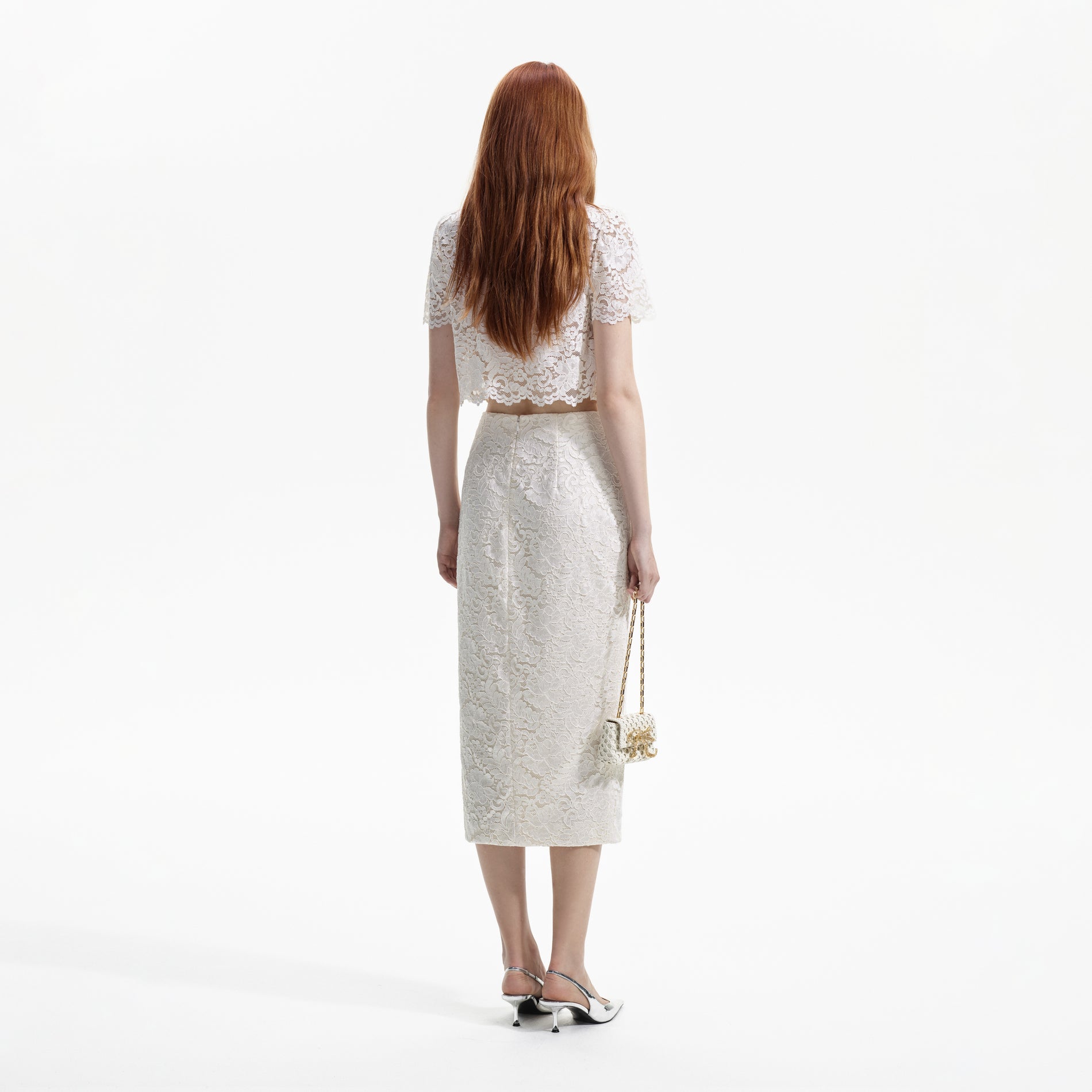 Back view of a woman wearing the Cream Cord Lace Split Midi Skirt
