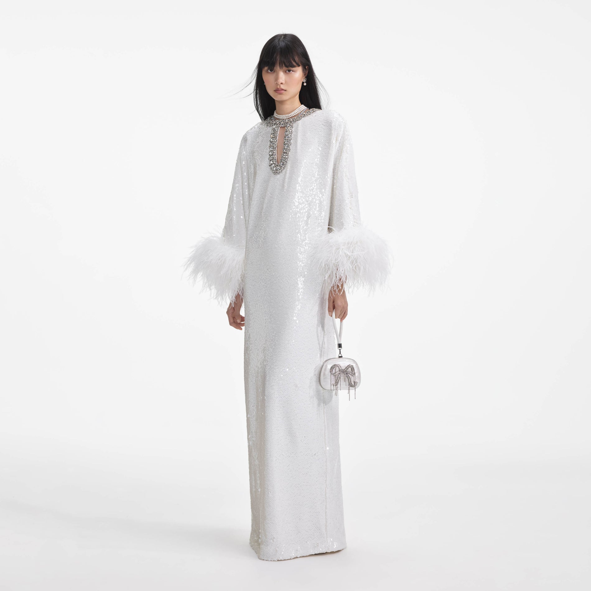 Side view of a woman wearing the White Sequin Feather Maxi Dress