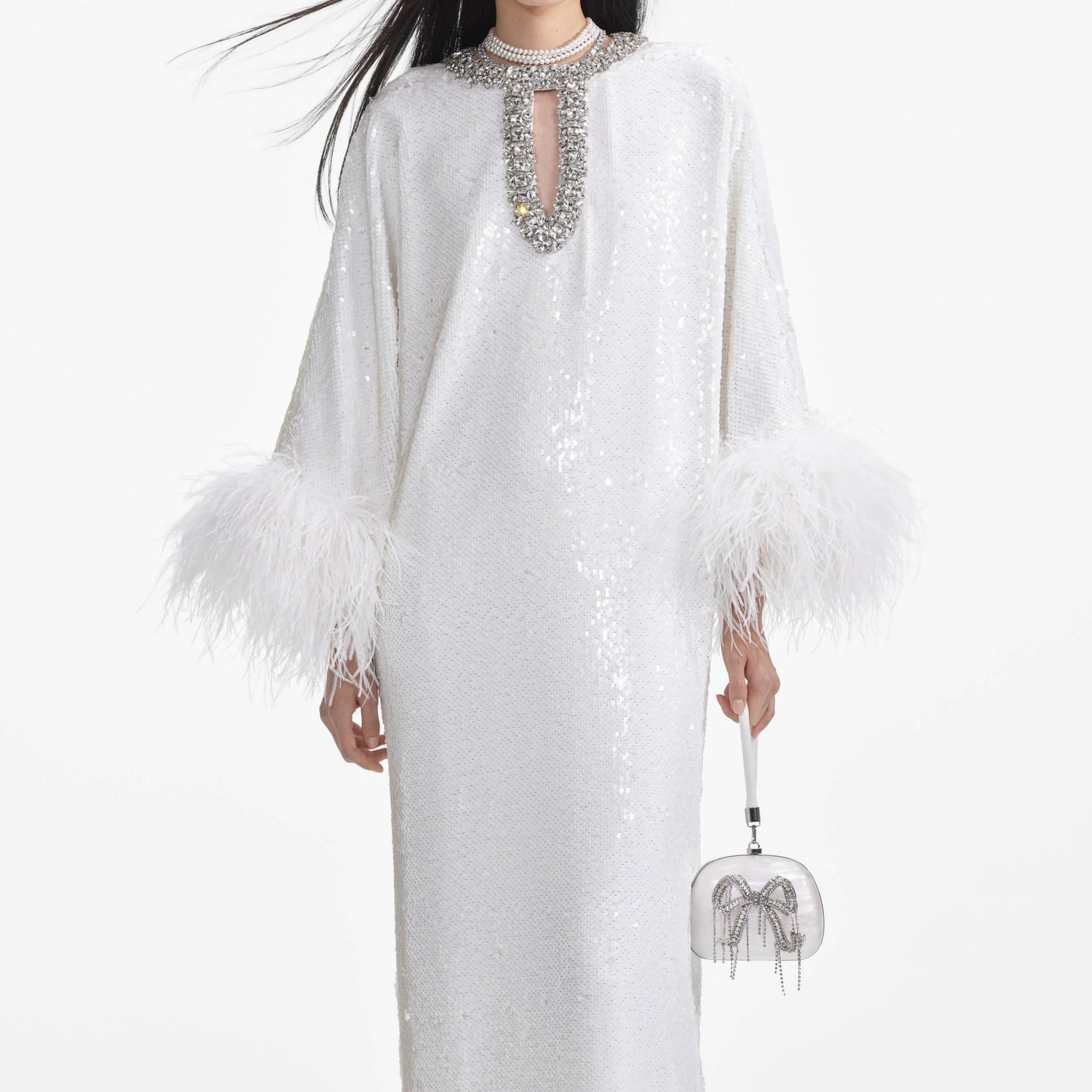 A close up of a woman wearing the White Sequin Feather Maxi Dress