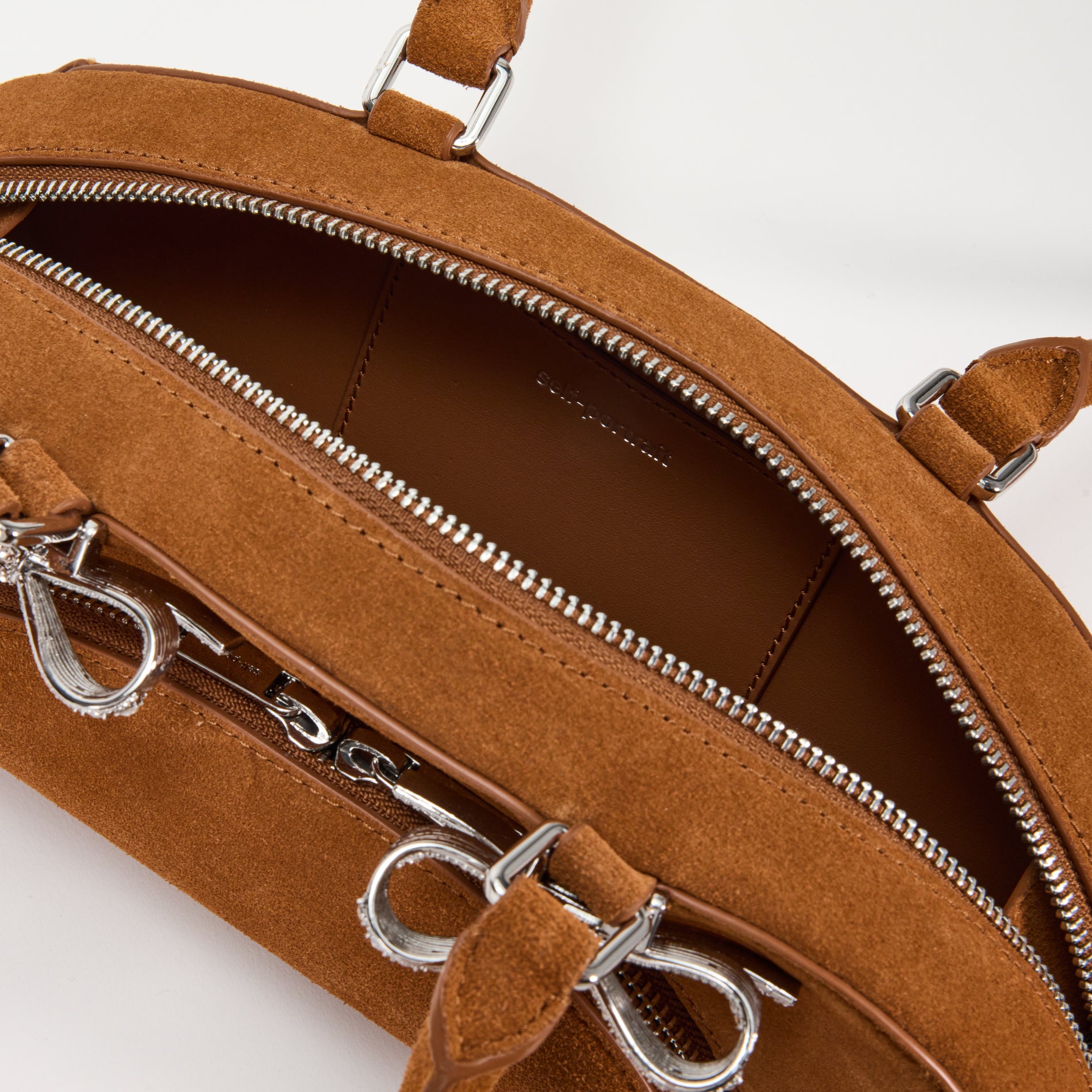 A close up of a woman wearing the Brown Suede Curved Shoulder Bag