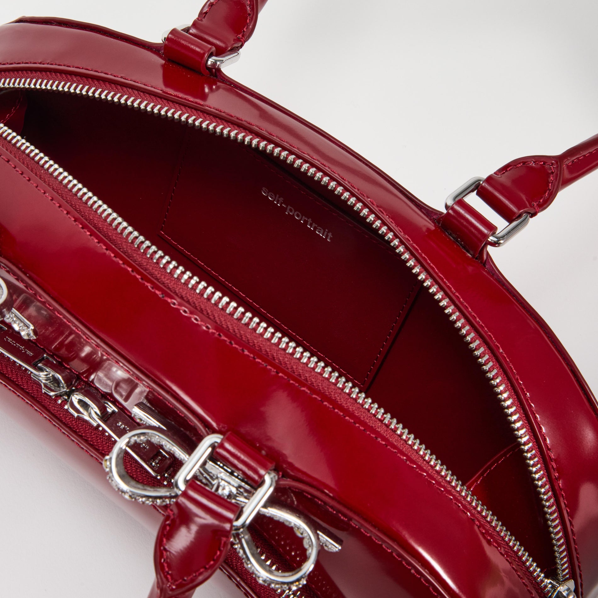 A close up of a woman wearing the Burgundy Leather Curved Shoulder Bag