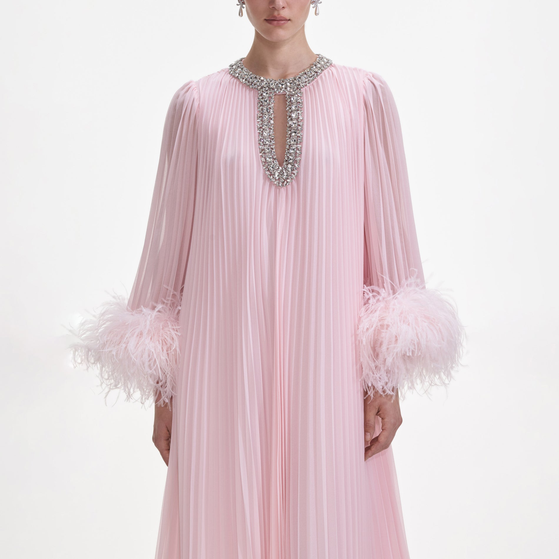 A close up of a woman wearing the Pink Chiffon Feather Midi Dress