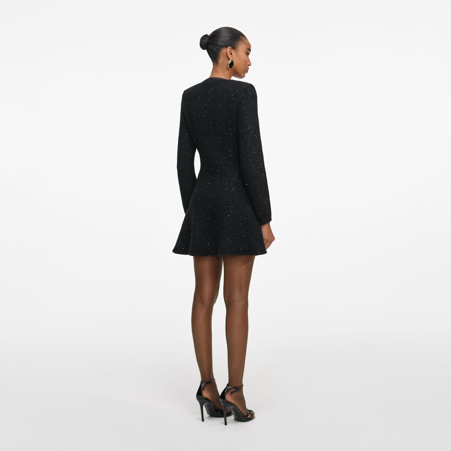 Back view of a woman wearing the Black Sequin Knit Mini Dress
