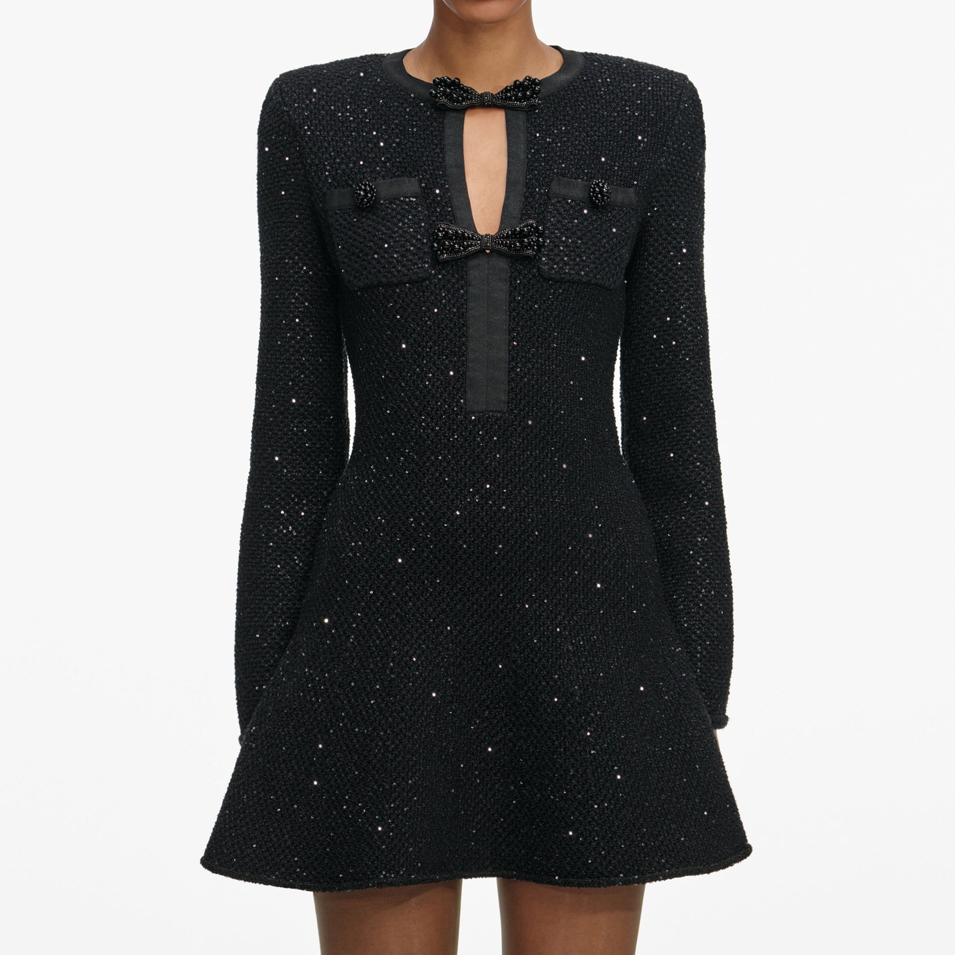 A close up of a woman wearing the Black Sequin Knit Mini Dress