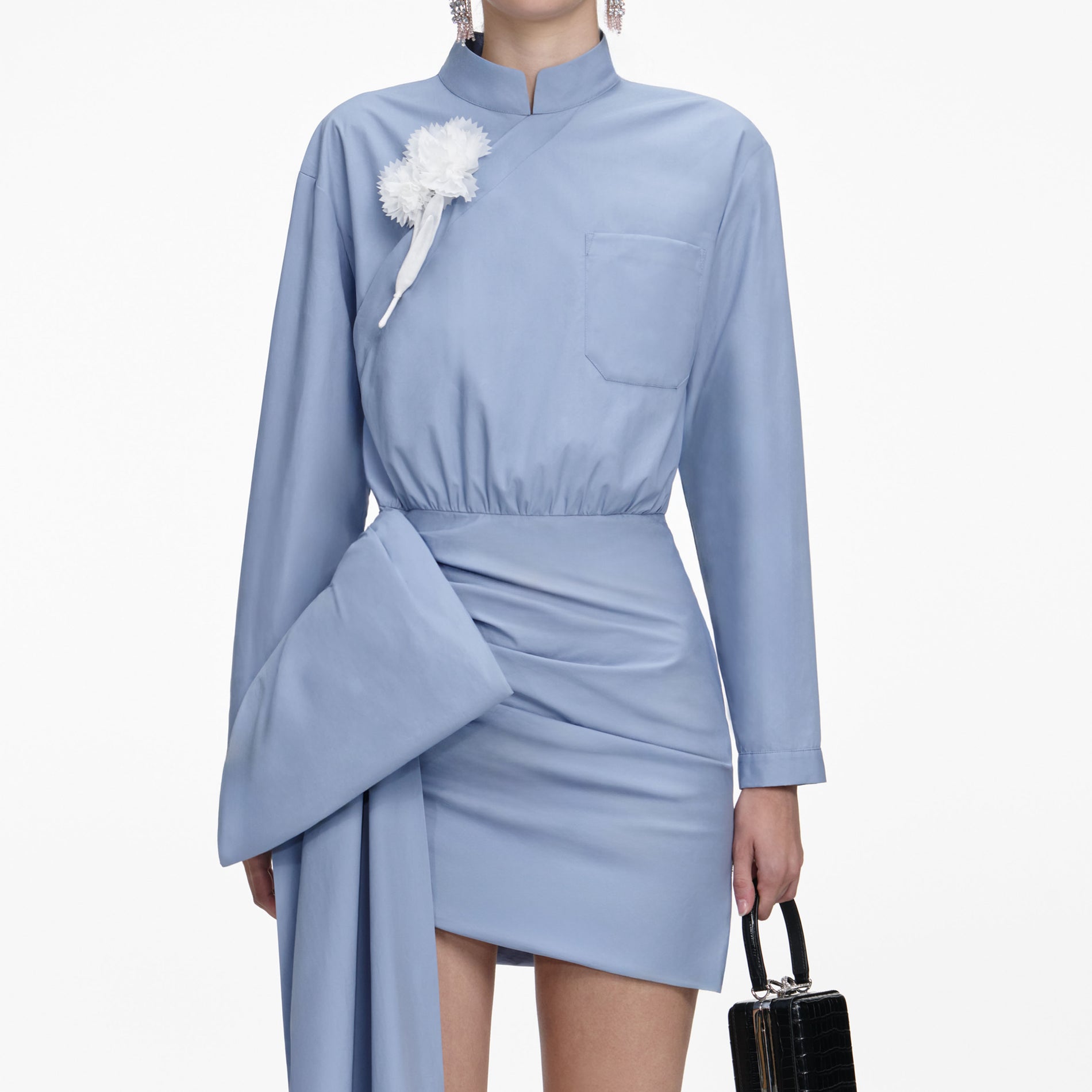 A close up of a woman wearing the Blue Cotton Tie Side Mini Dress