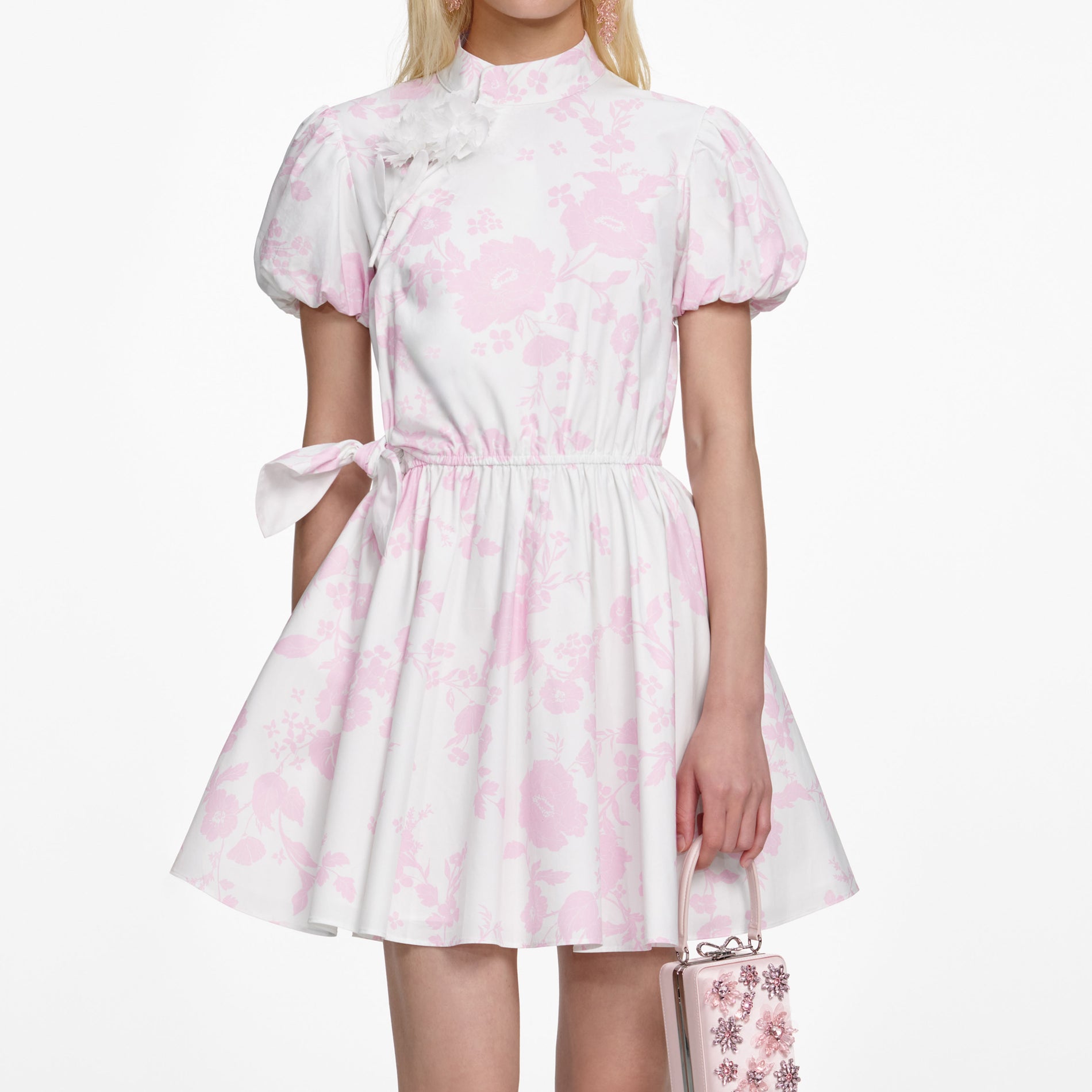 A close up of a woman wearing the Pink Floral Cotton Drape Mini Dress